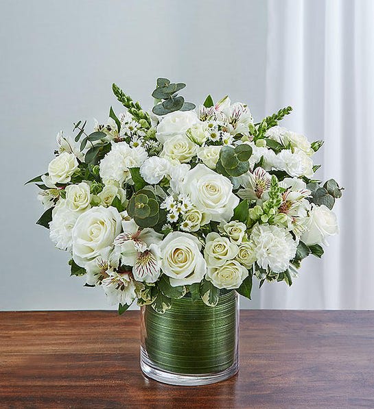 Cherished Memories - All White - Send a gift of lasting tribute and touching remembrance of a life well lived. This striking, all-white arrangement of roses, spray roses, snapdragons, alstroemeria, carnations and more, elegantly arranged by hand in a graceful cylinder vase. A lovely gift of comfort and honor. Fresh arrangement of white roses, spray roses, snapdragons, alstroemeria, carnations, 