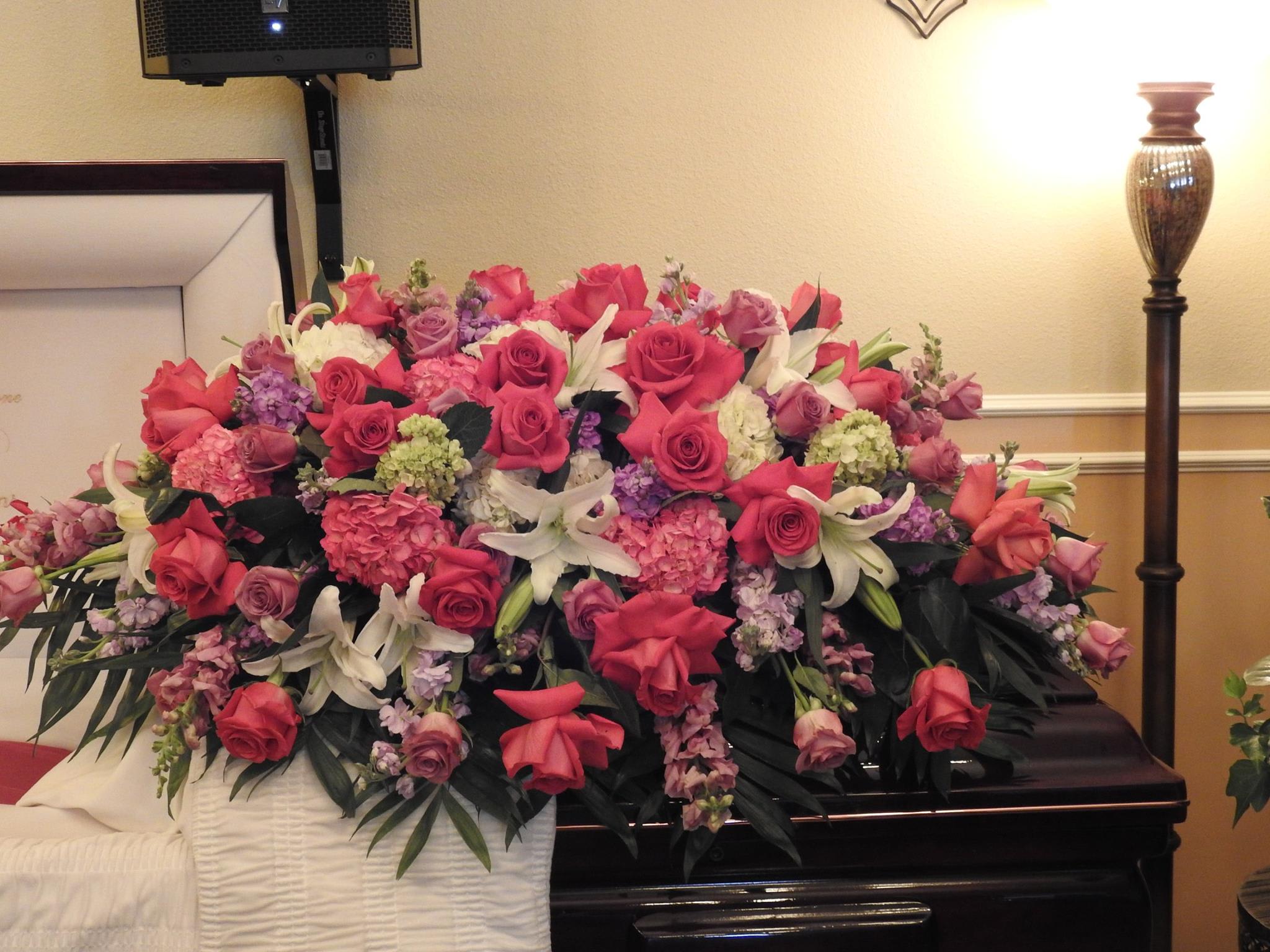 Large pink and white floral casket spray with roses and lilies