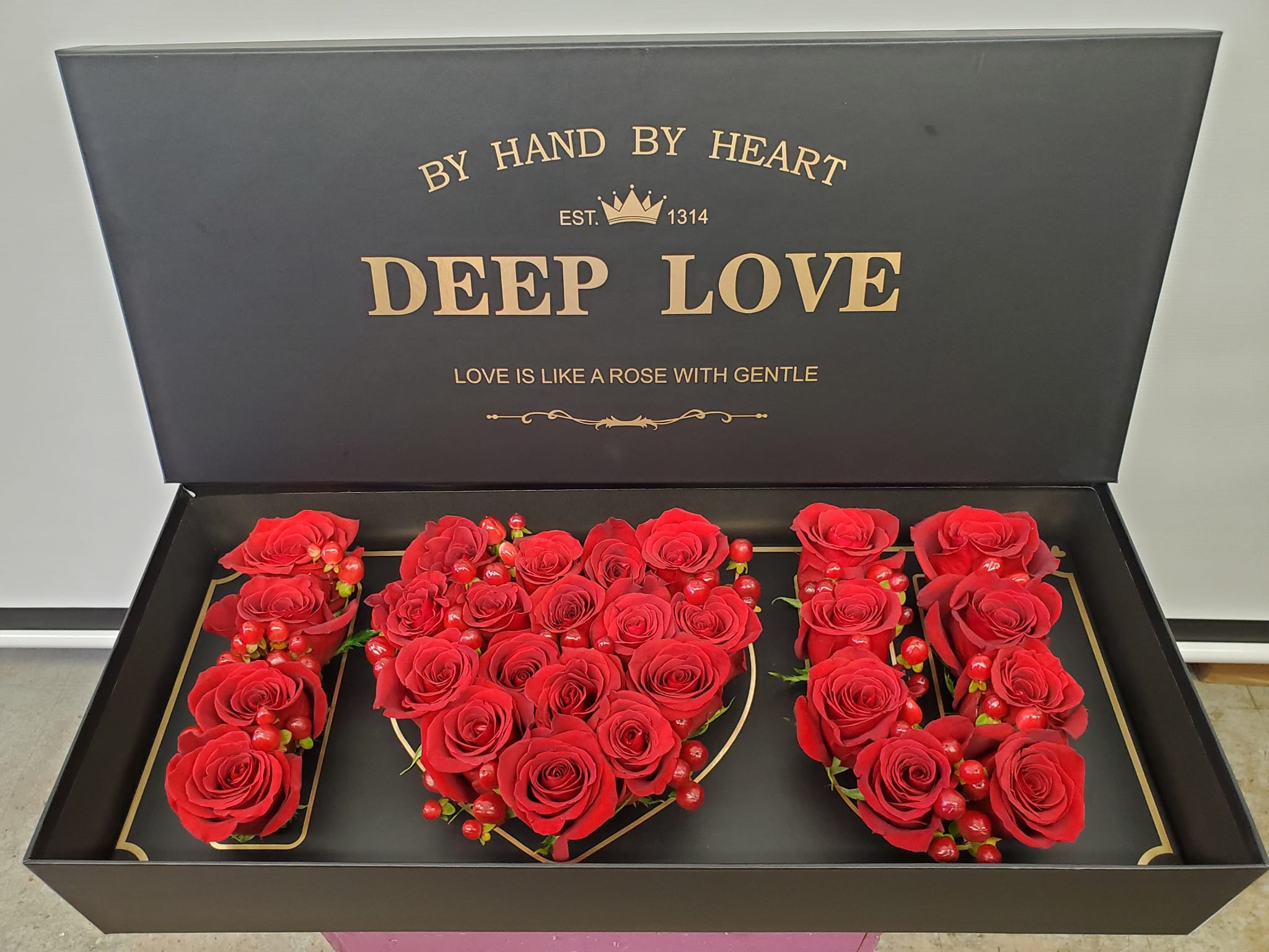 Red roses arranged in a gift box spelling "I LOVE U"