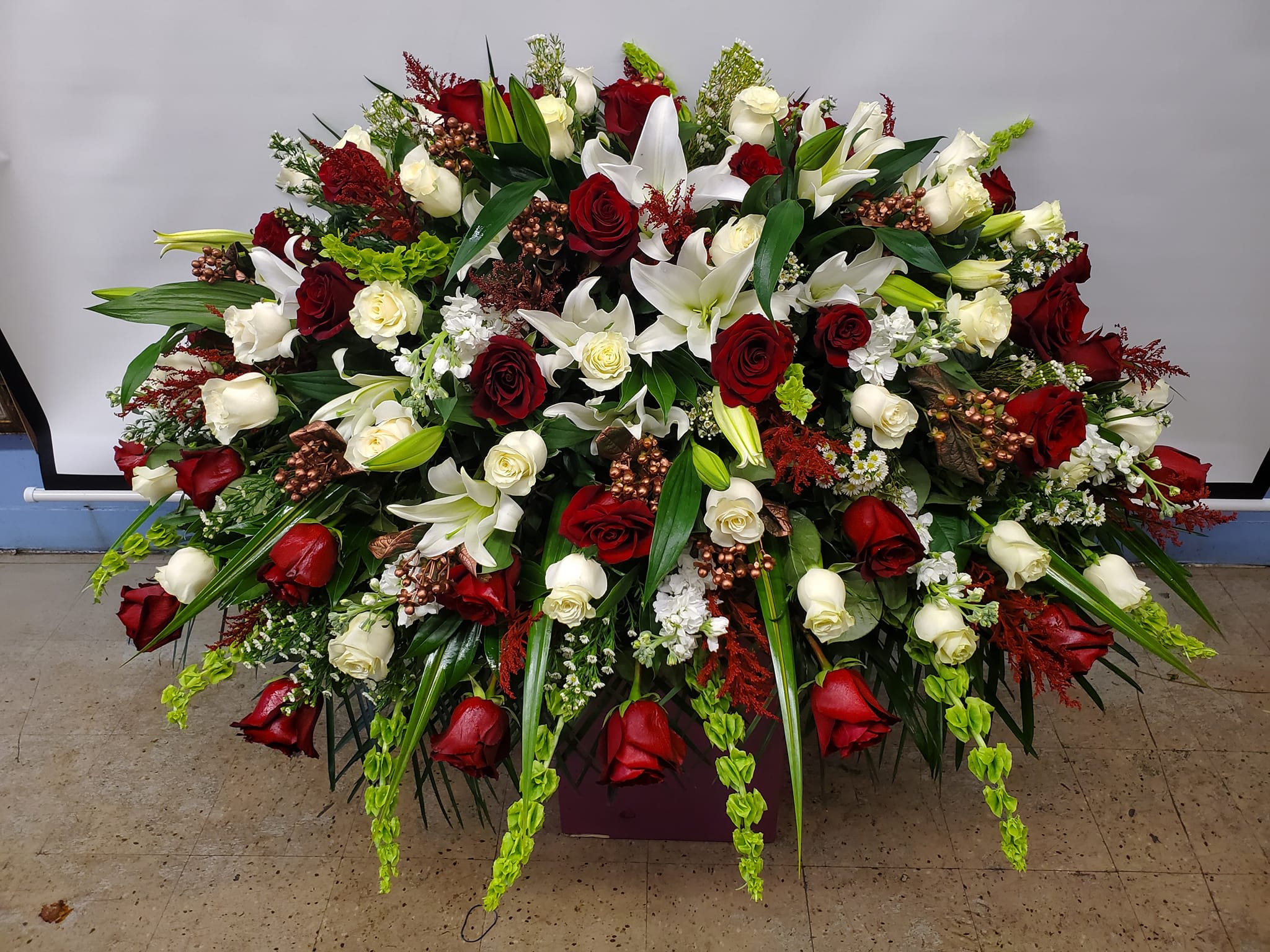 Large red and white floral spray with roses and lilies