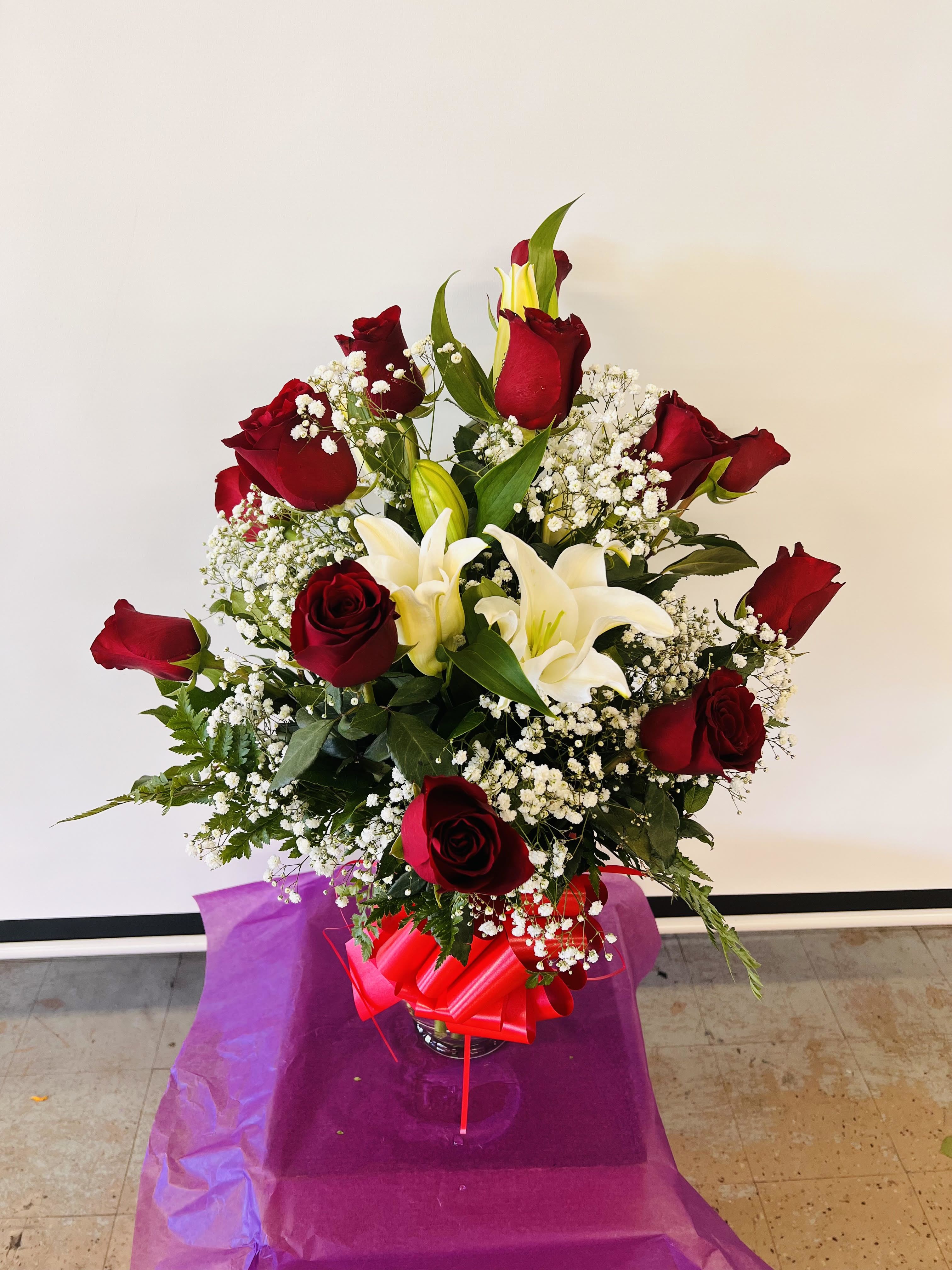 Bouquet of red roses and white lilies in a glass vase