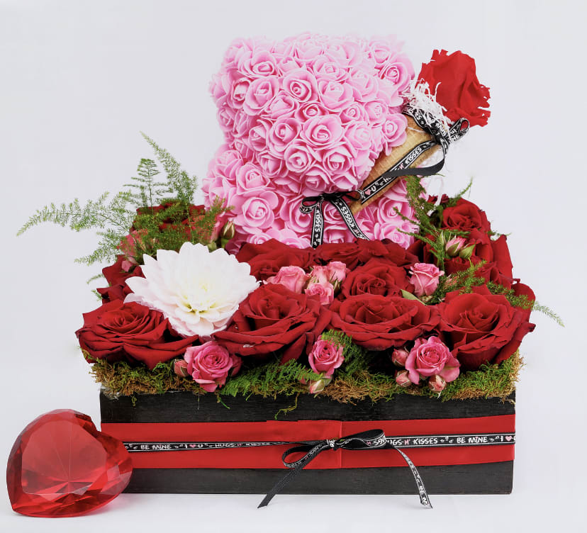 Pink rose teddy bear with red roses in a gift box and a red heart