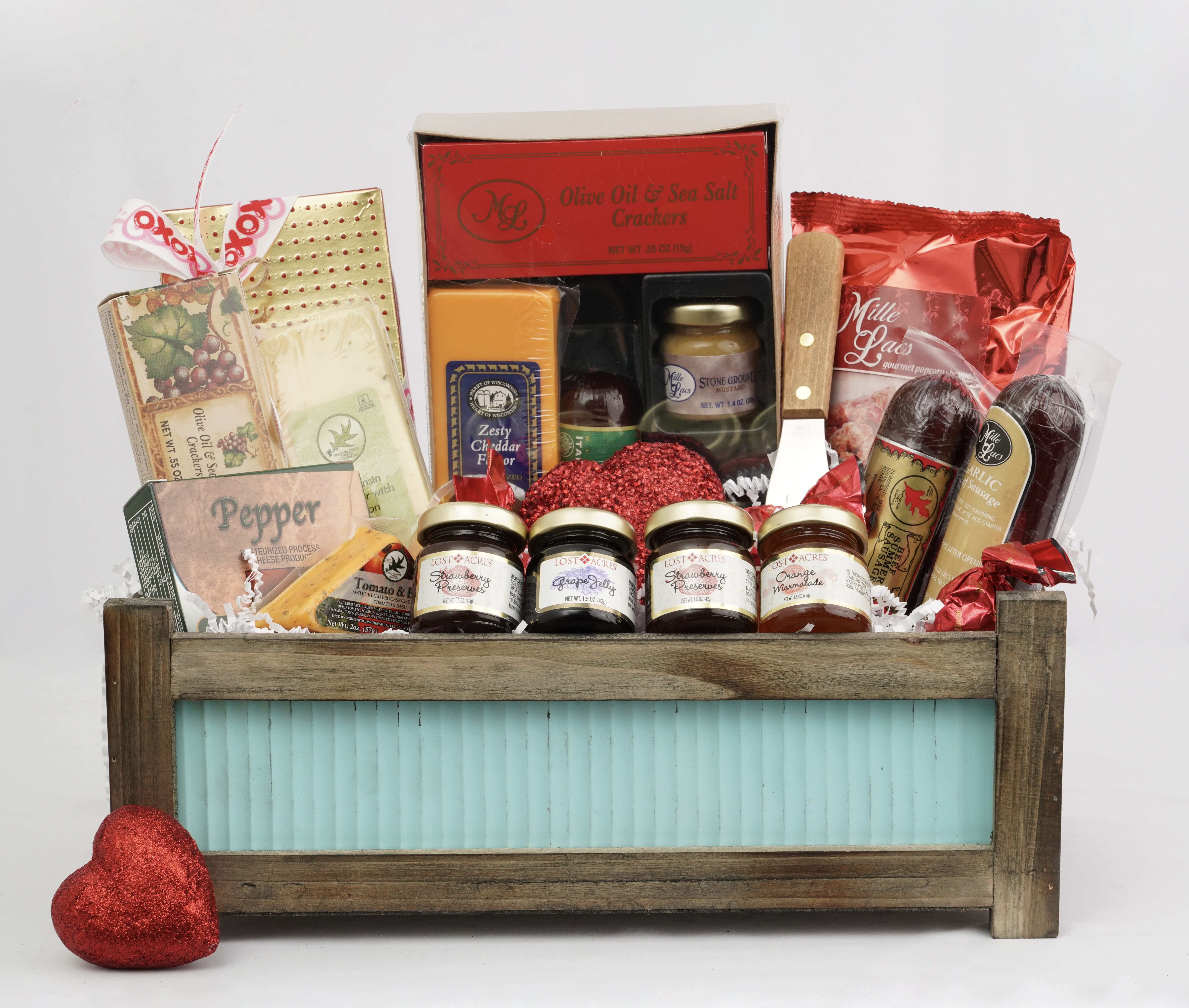 Gift basket with crackers, jams, and chocolates in a wooden crate