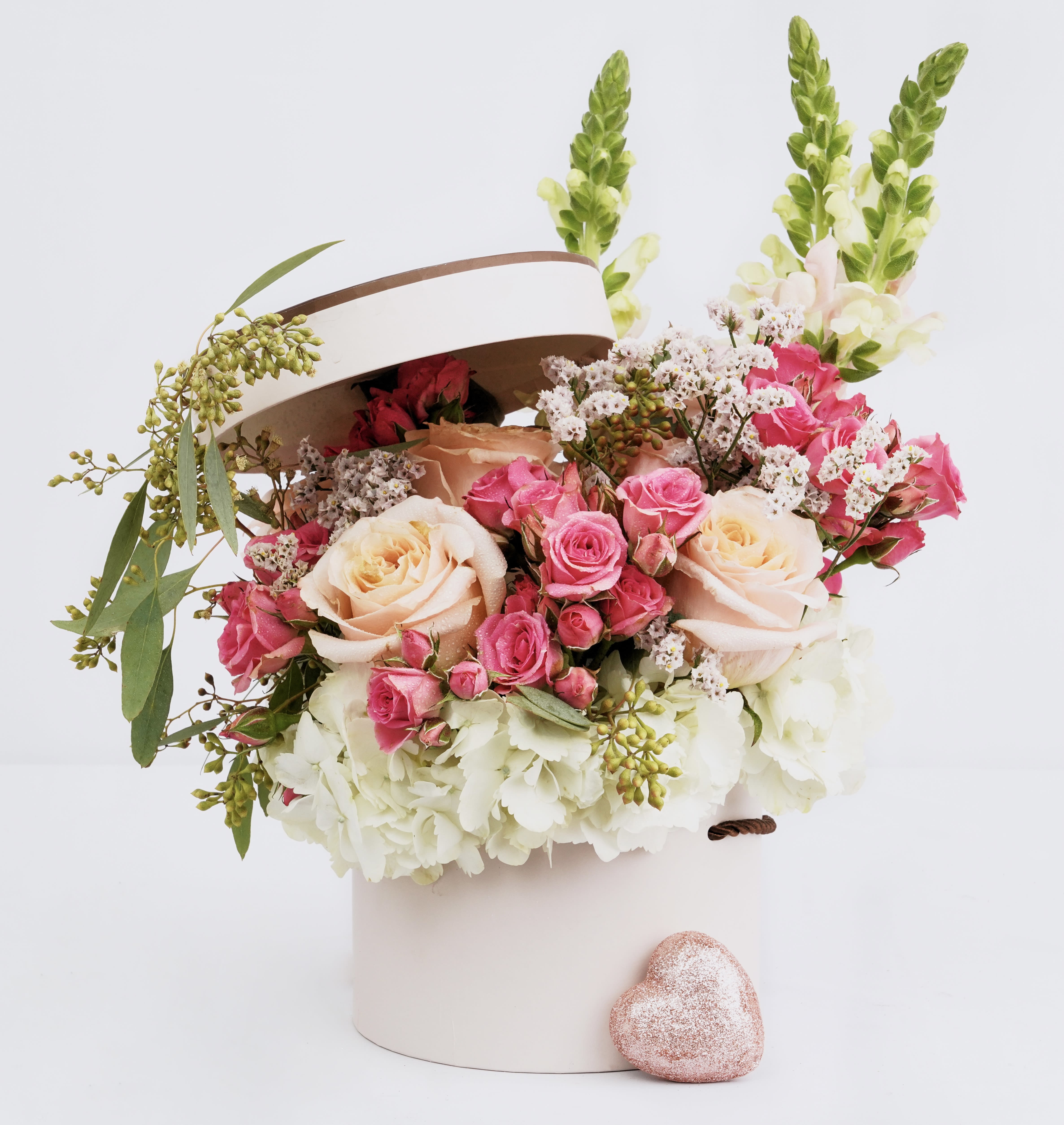 Pink and cream roses in a white hatbox with a glittery heart