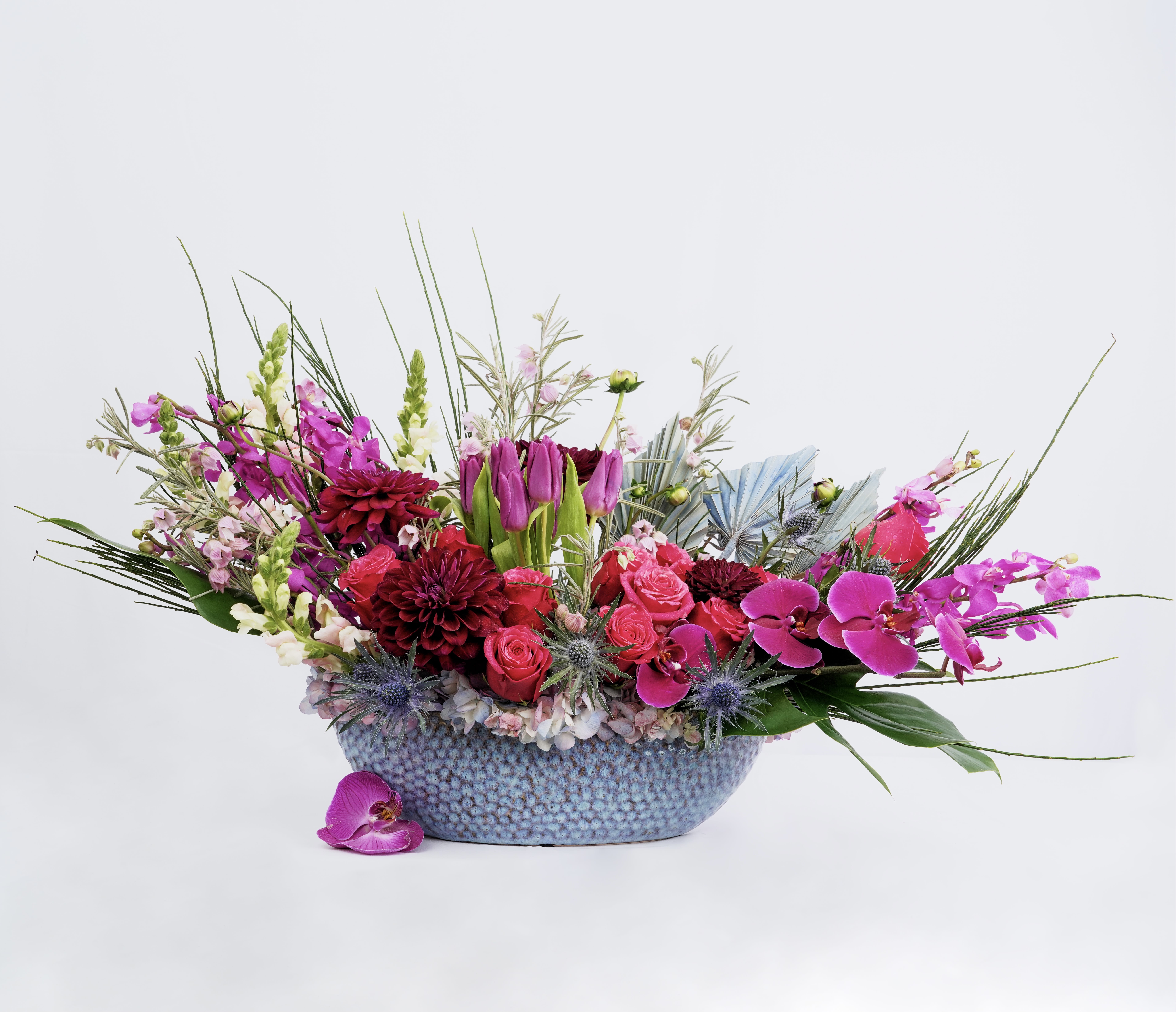 Mixed bouquet in a blue textured bowl with pink and purple flowers