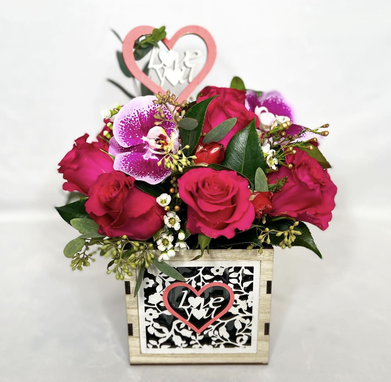Pink rose arrangement in a decorative wooden box with a heart topper