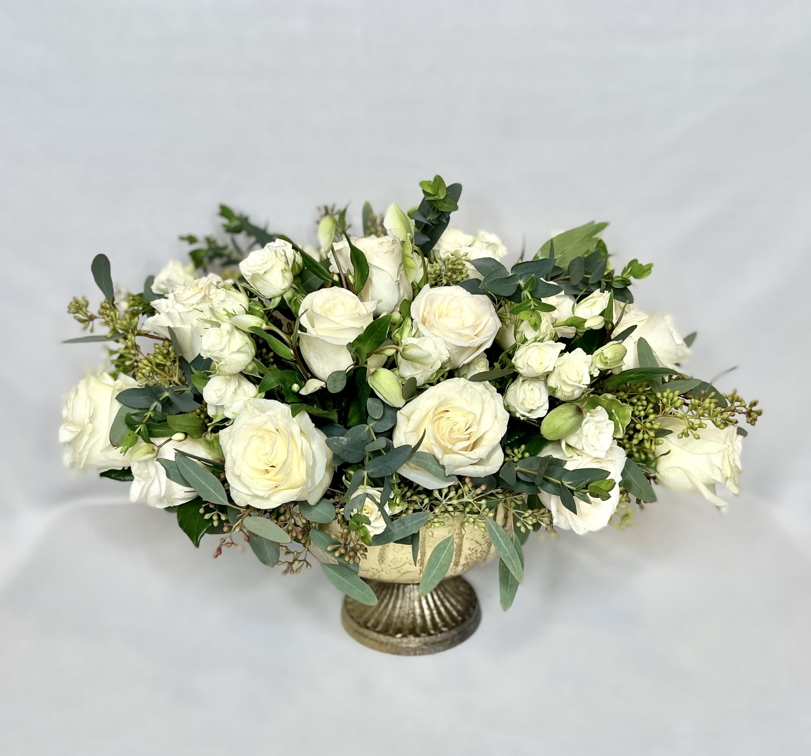 White rose bouquet in a gold pedestal vase