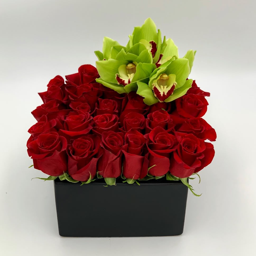 Red roses with green orchids in a black rectangular box