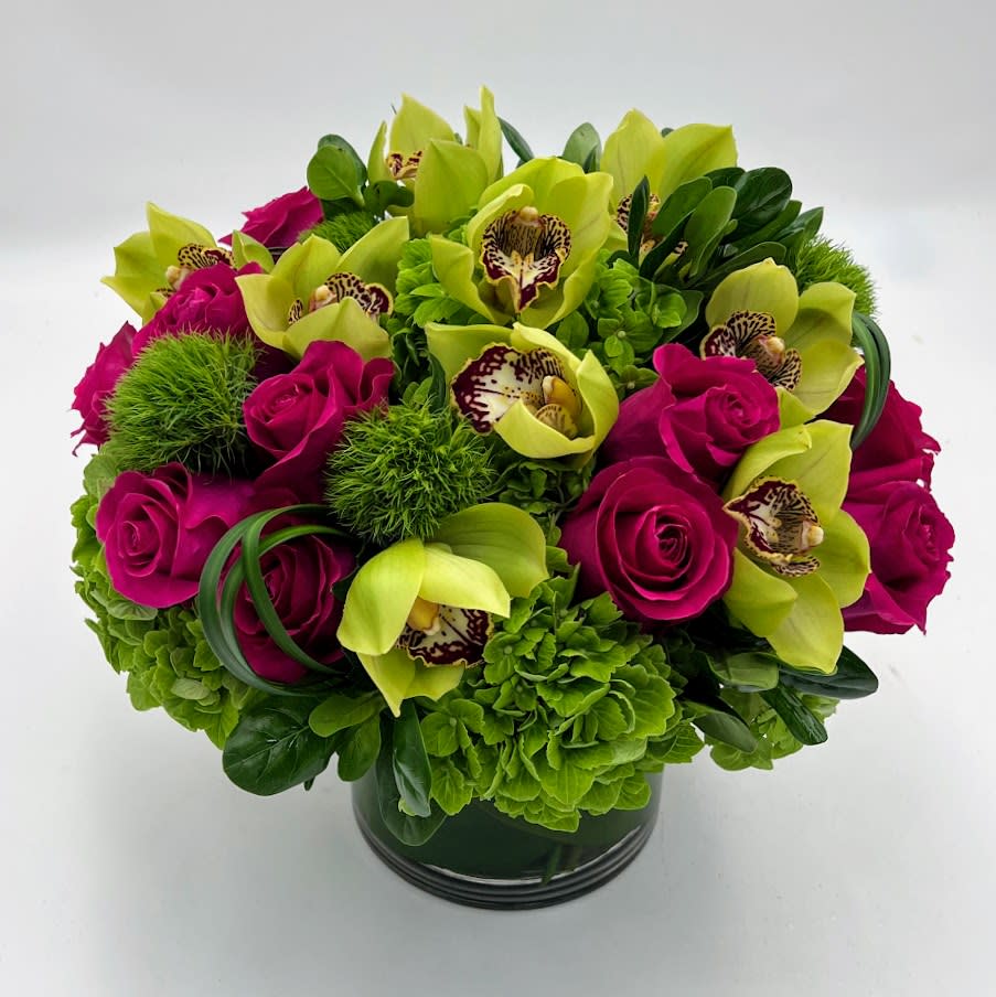 Bouquet of magenta roses and green orchids in a dark vase