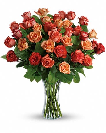 Bouquet of orange and red roses in a clear glass vase