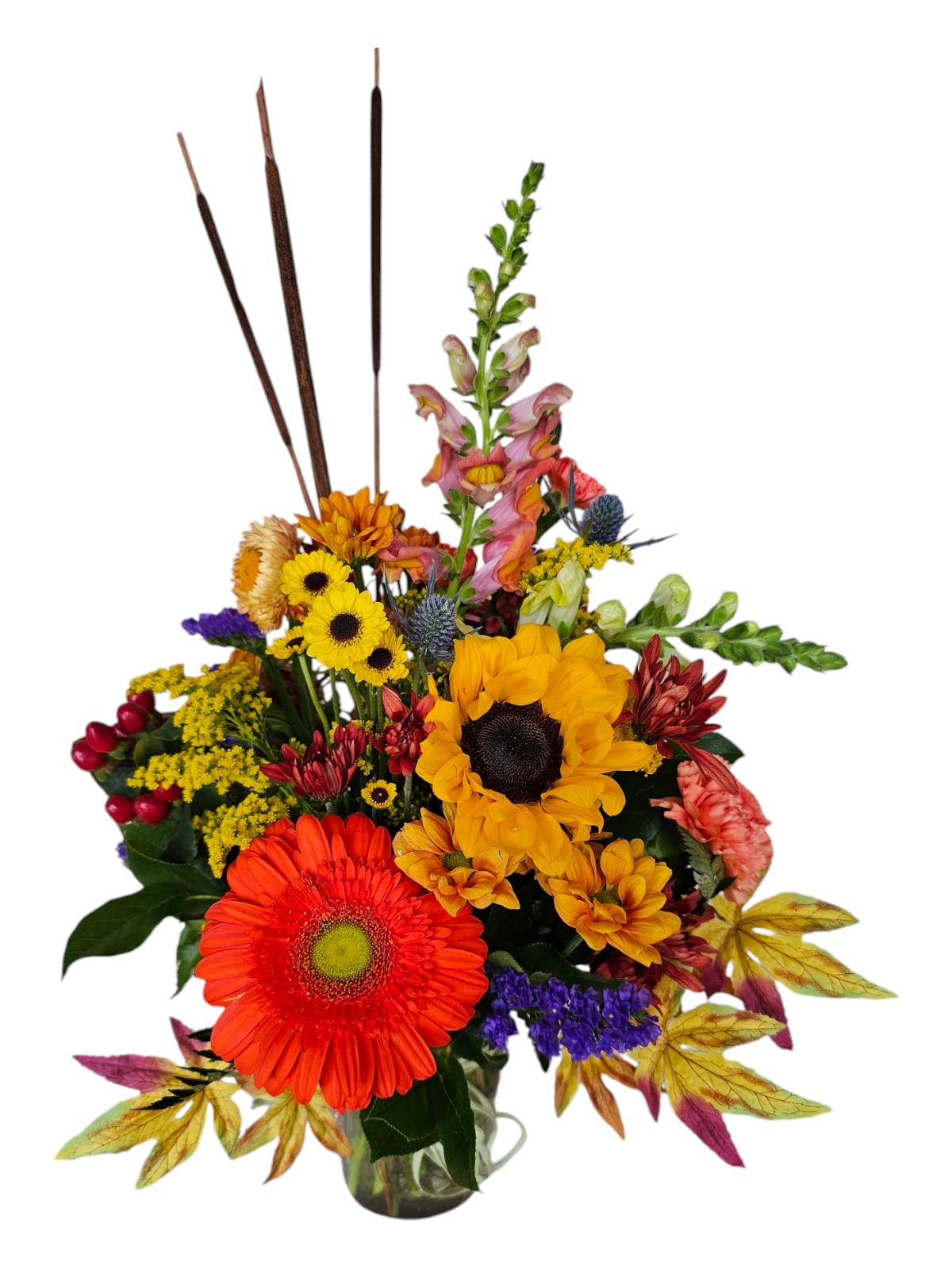 Colorful mixed flower arrangement in a glass vase with sunflowers and gerbera daisies