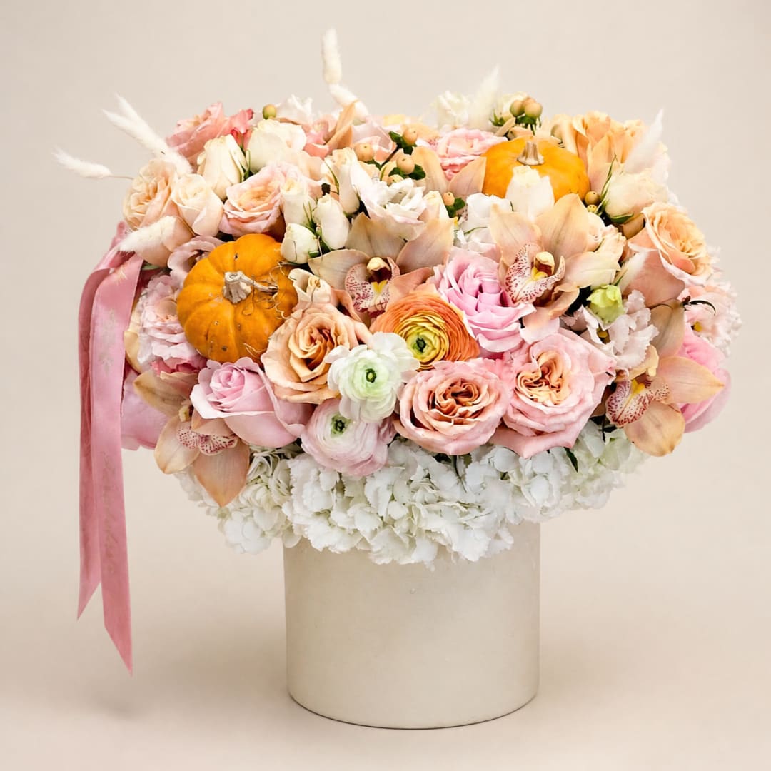 Pastel bouquet with roses, orchids, and small pumpkins in a white hat box