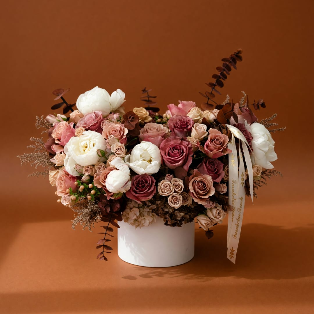 Pink and white rose arrangement in a white vase
