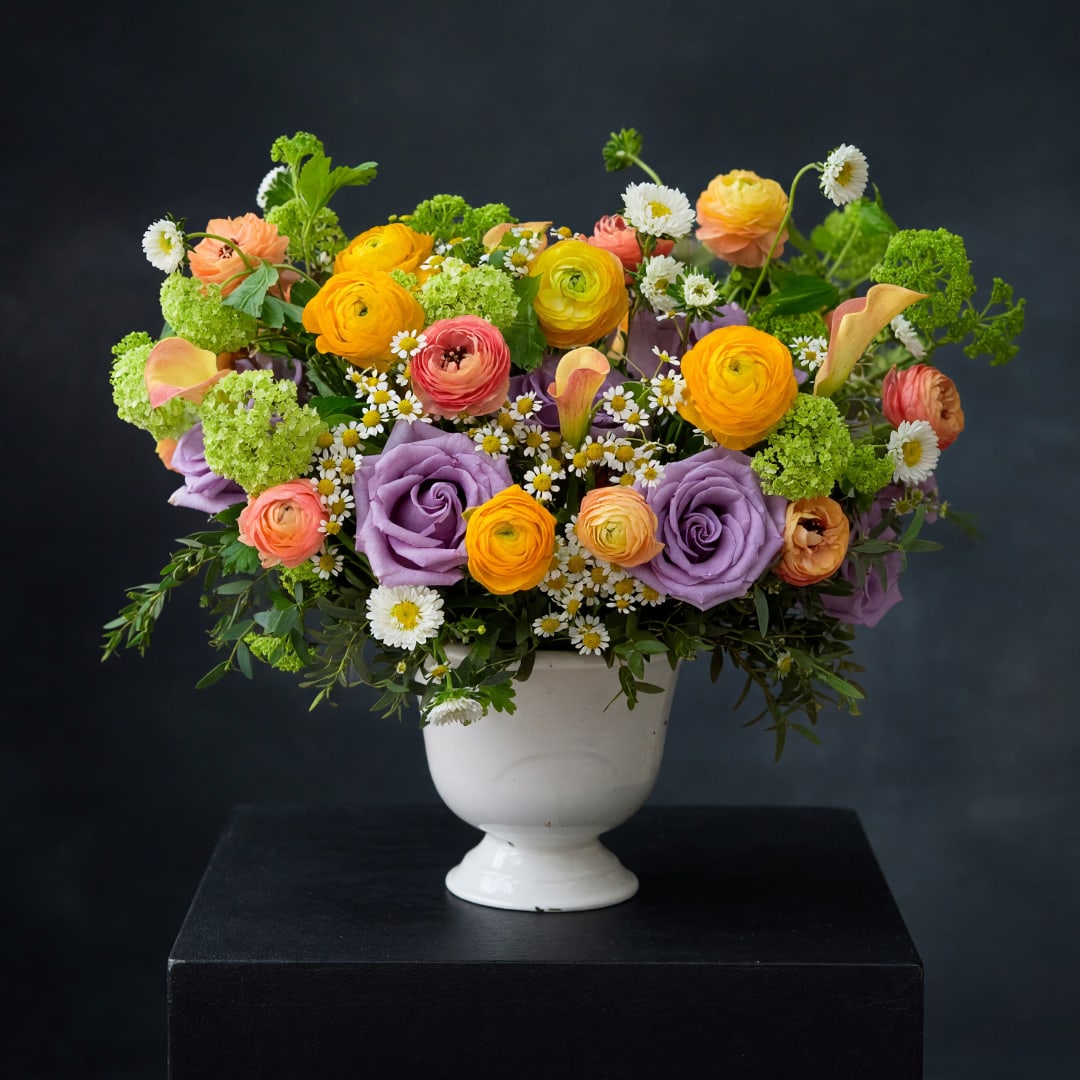 Colorful mixed bouquet in a white pedestal vase