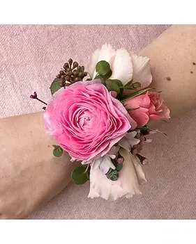 Pink Corsage - Add a touch of natural elegance to your special occasion with this beautifully handcrafted wrist corsage. Featuring delicate white blooms paired with fresh green leaves and subtle berry accents, this piece creates a soft, romantic look. 