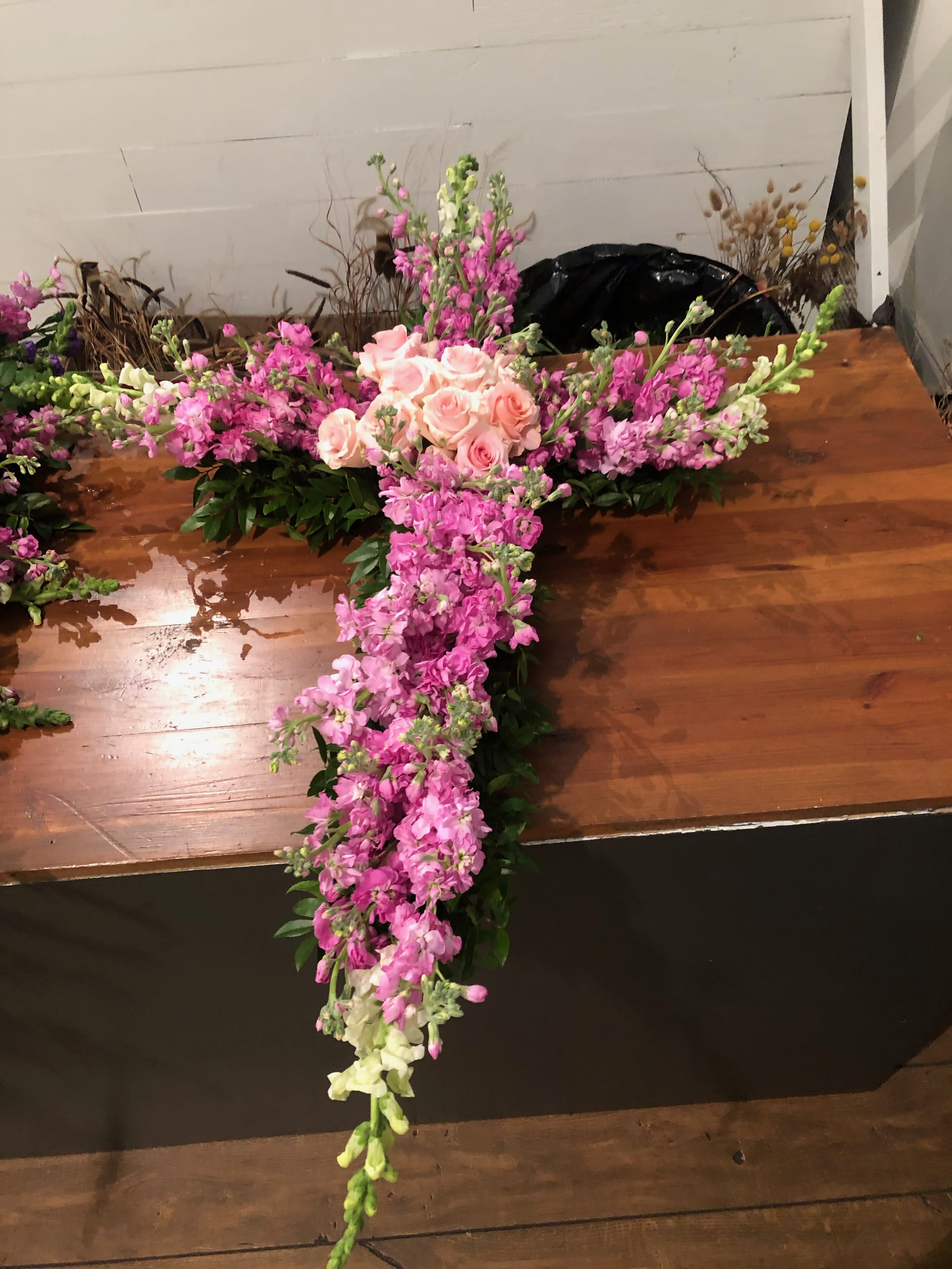 Cross-shaped floral arrangement with pink roses and pink-and-white blooms