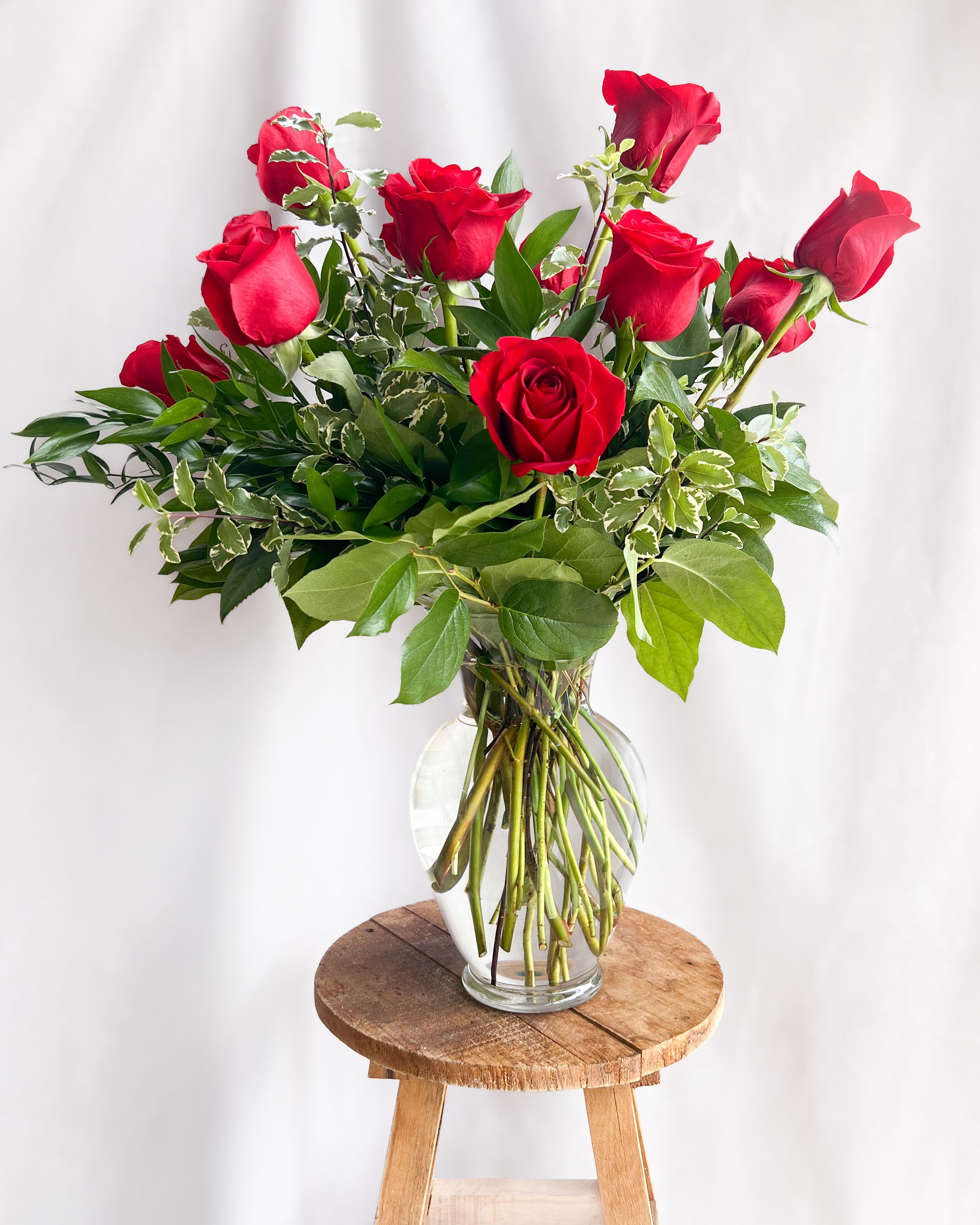 Red roses arranged in a clear glass vase