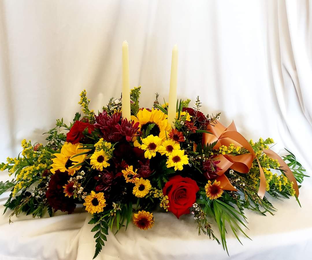 The Autumn - Full and lush Thanksgiving centerpiece with candles, golden yellow sunflowers, roses, and mums. 