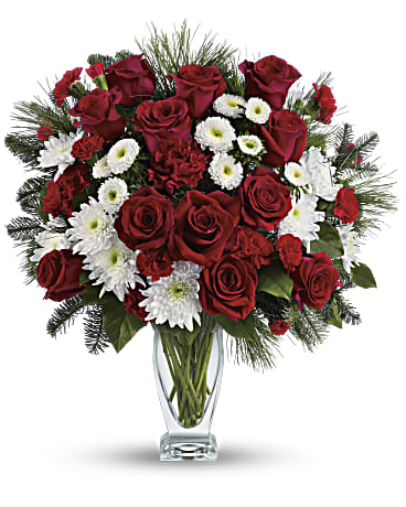 Red roses and white daisies in a clear glass vase