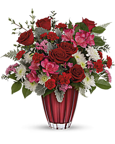 Red and pink mixed flower bouquet in a red vase