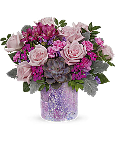 Pink roses and magenta flowers arranged in a purple glass vase