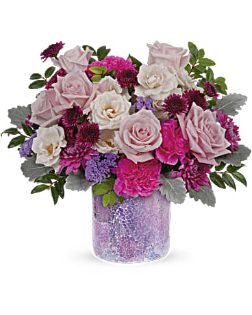 Pink and white rose bouquet in a purple glass vase