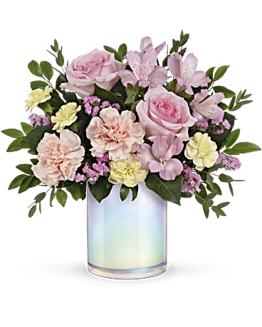 Pink and peach flowers arranged in an iridescent glass vase