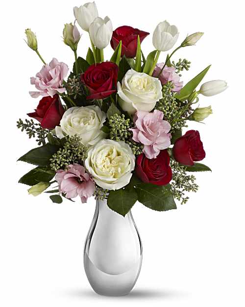 Bouquet of red, white, and pink roses in a clear glass vase