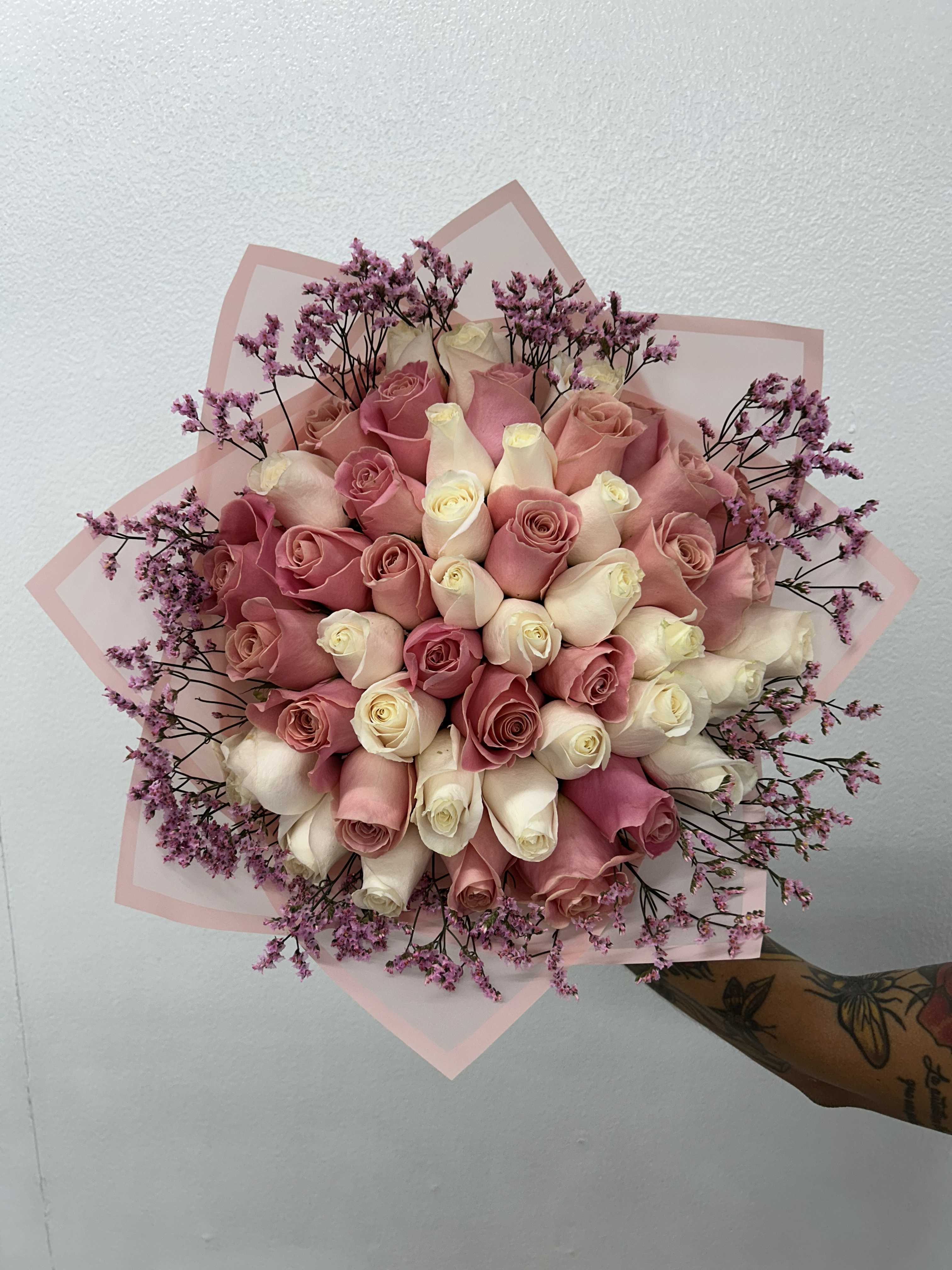Bouquet of pink and white roses with purple filler flowers