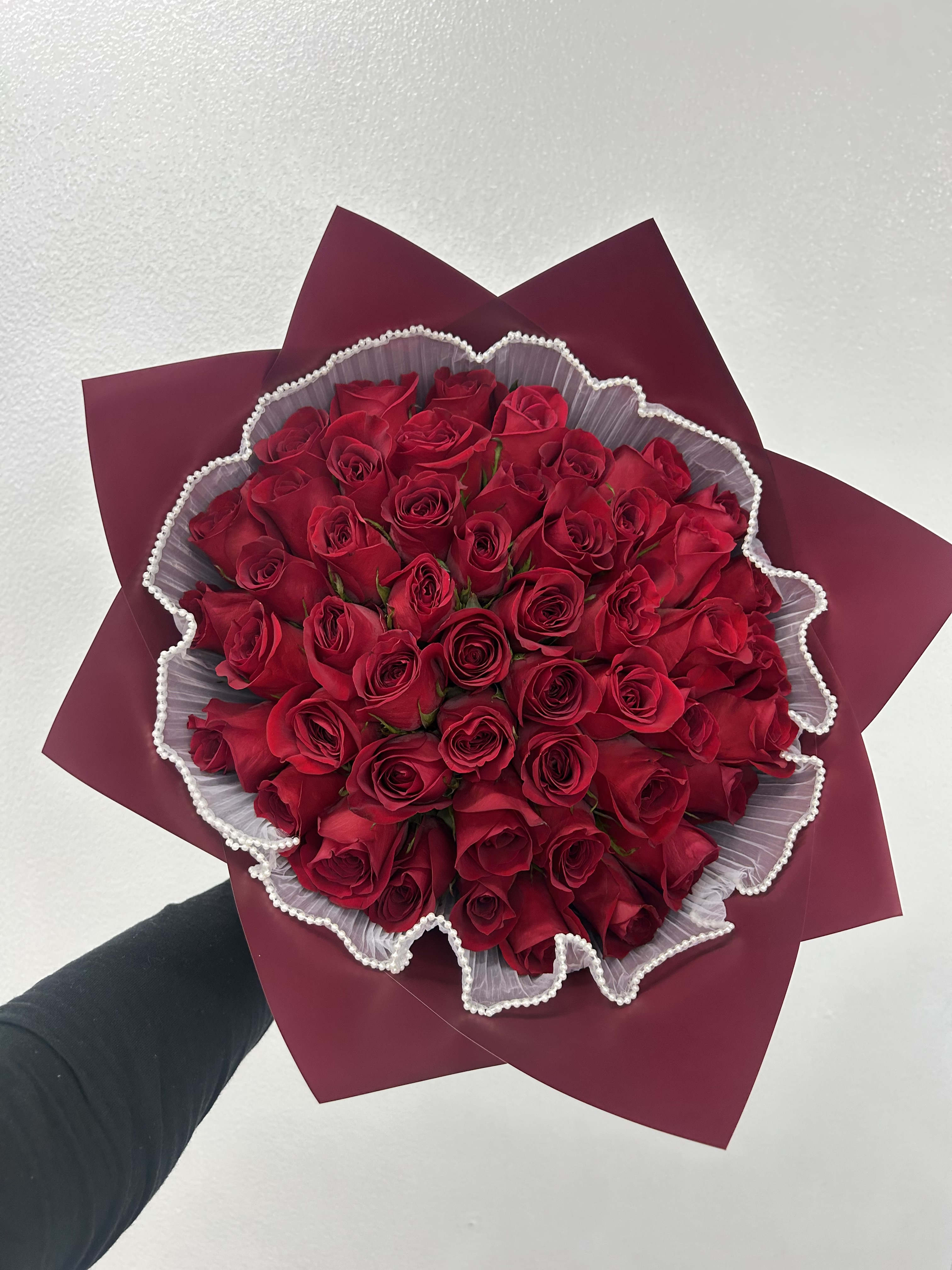 Bouquet of red roses wrapped in burgundy paper