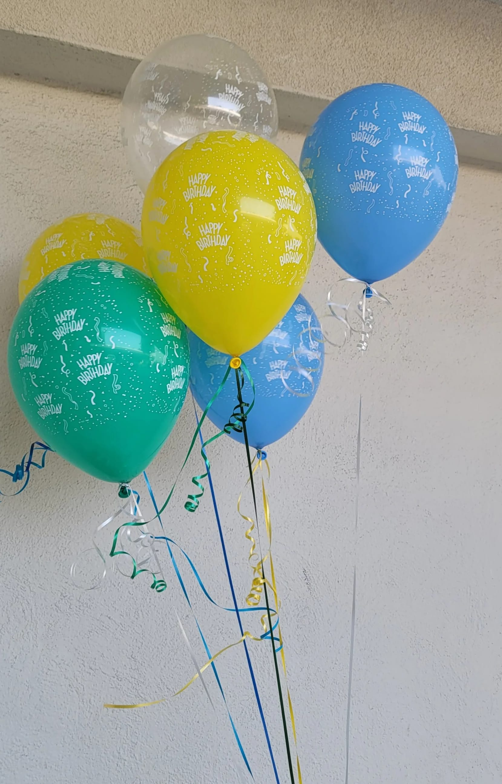 Cluster of colorful birthday balloons with curling ribbons