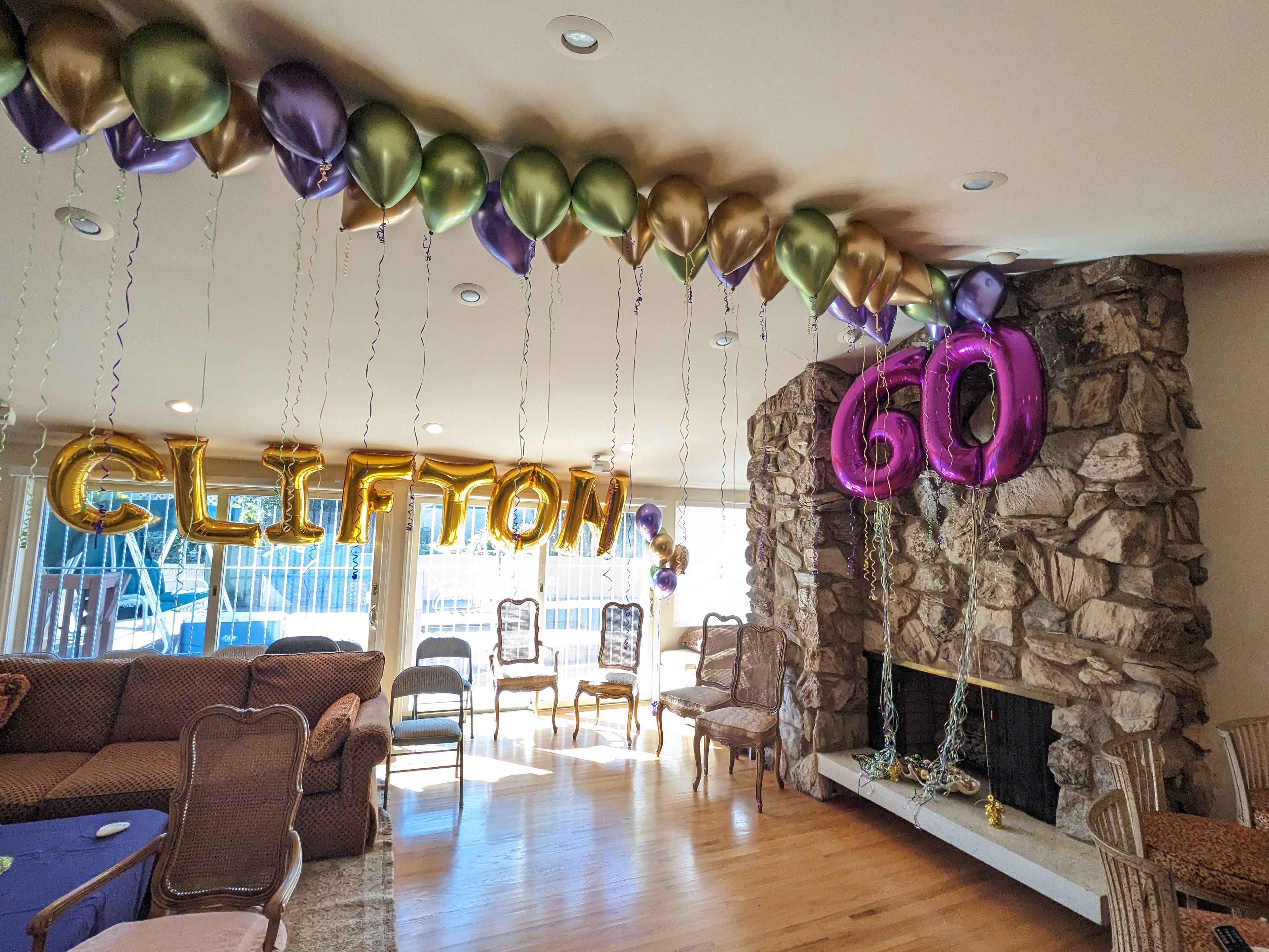 Balloon decorations spelling "CLIFTON" and "60" in a living room