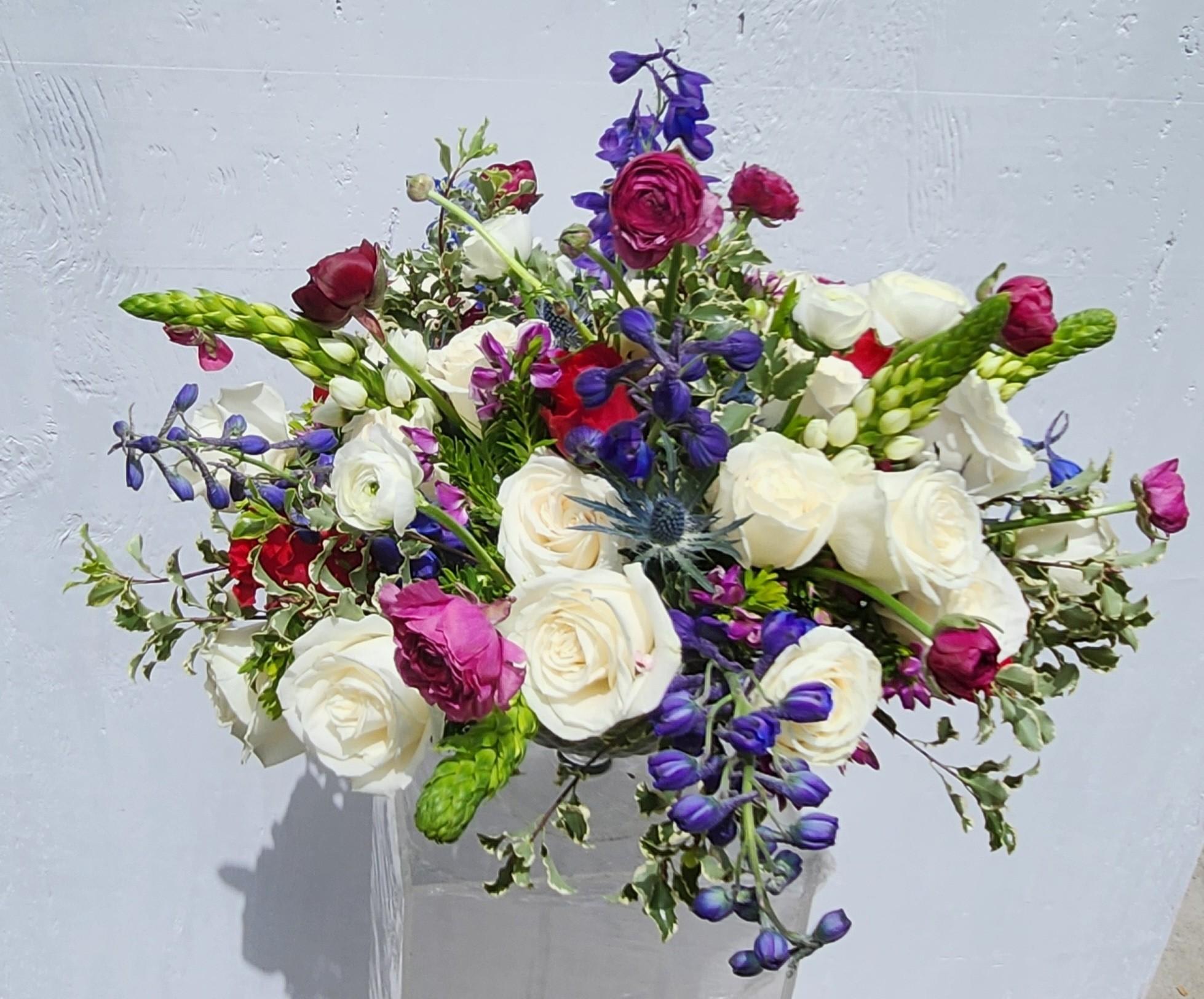 Bouquet of white, pink, and purple flowers in a clear vase