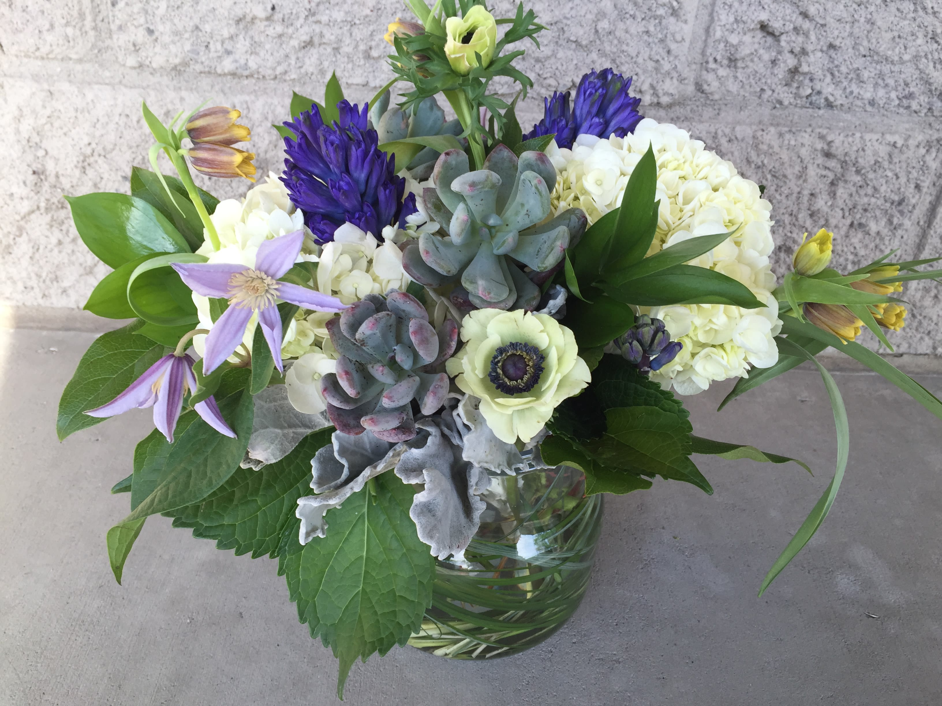 Mixed bouquet with purple and white flowers in a glass vase