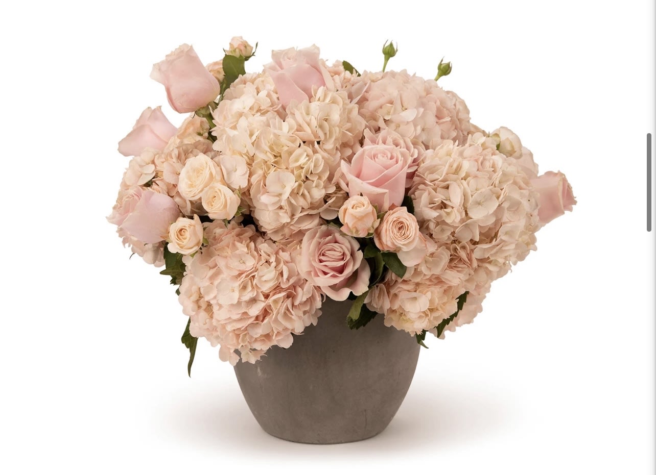 Blush pink roses and hydrangeas arranged in a gray vase