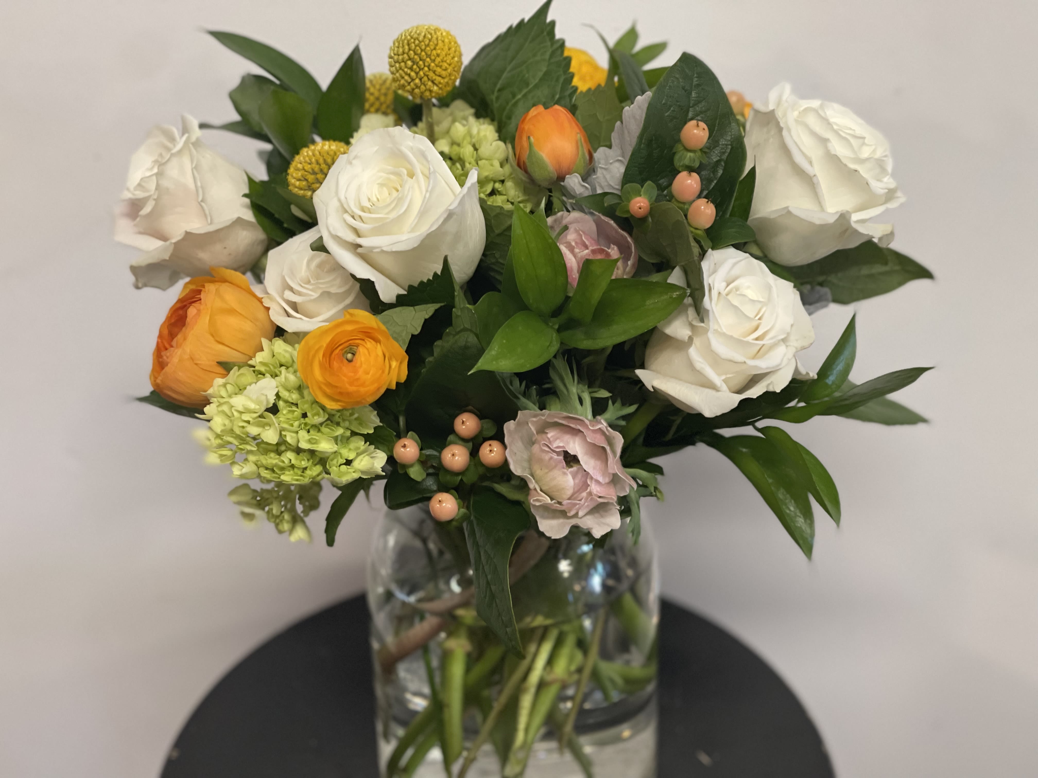 Mixed bouquet of white and orange flowers in a glass vase