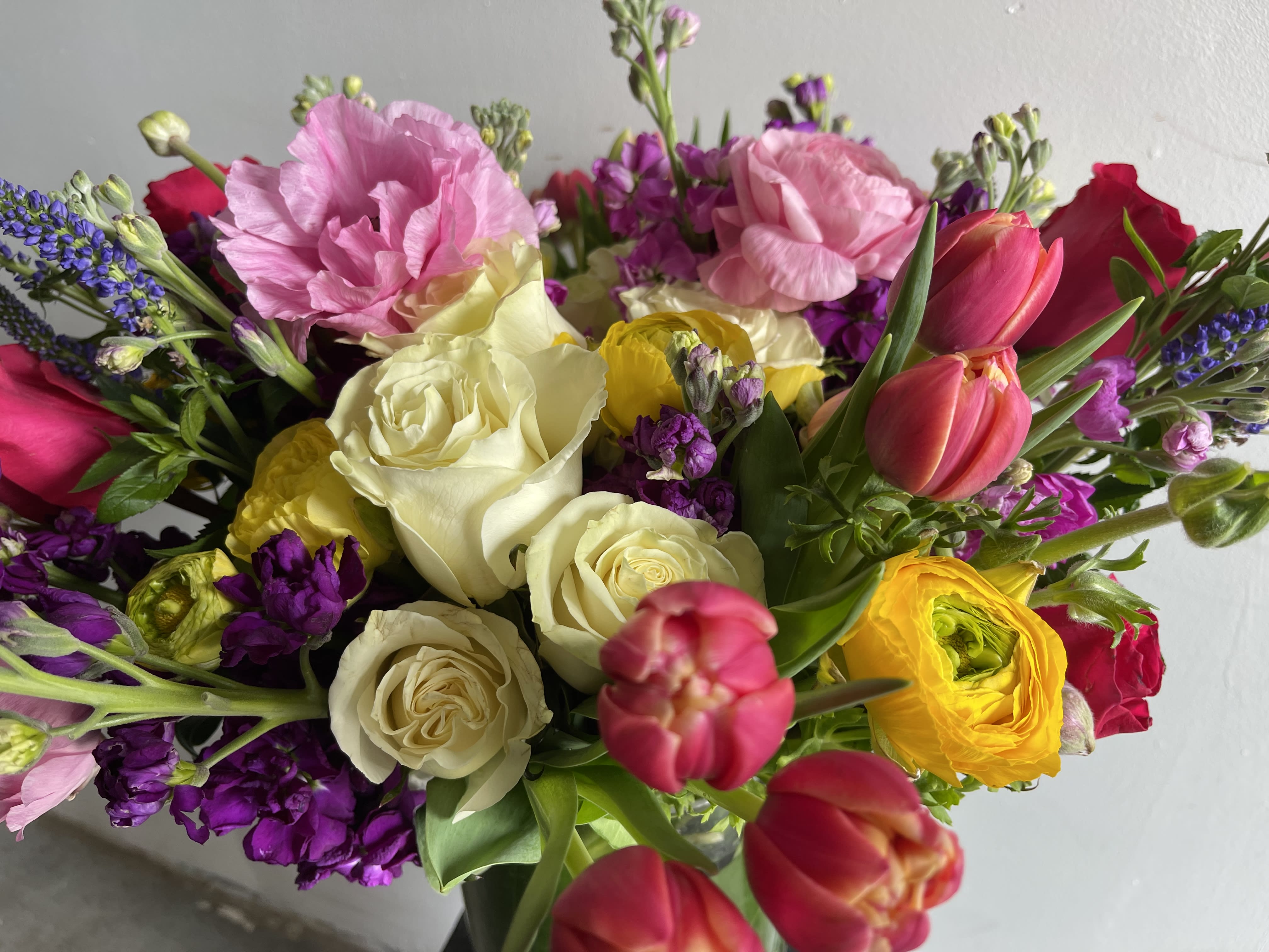 Mixed bouquet with roses, tulips, and pink blooms in bright colors