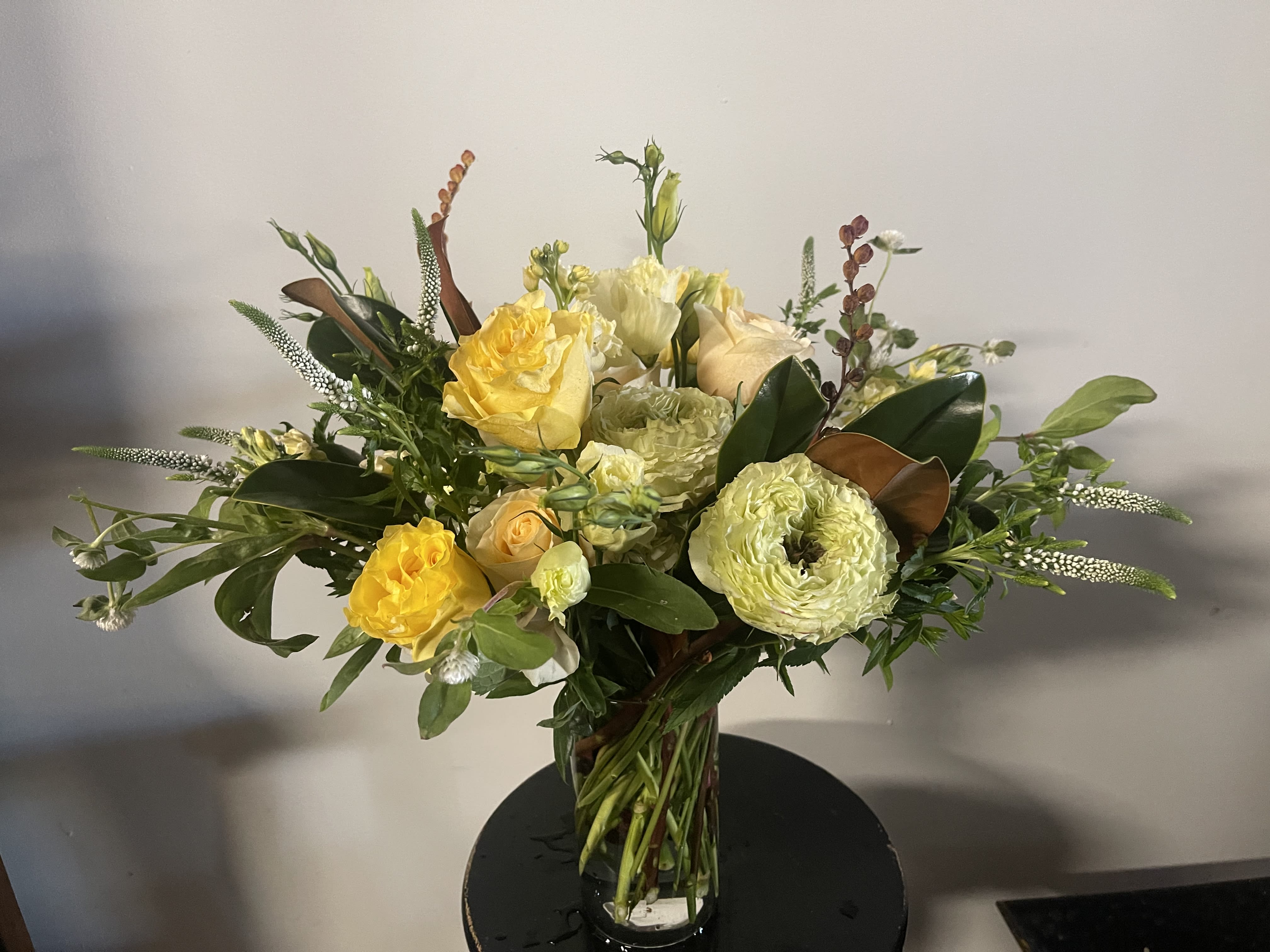 Yellow and cream rose bouquet in a clear glass vase