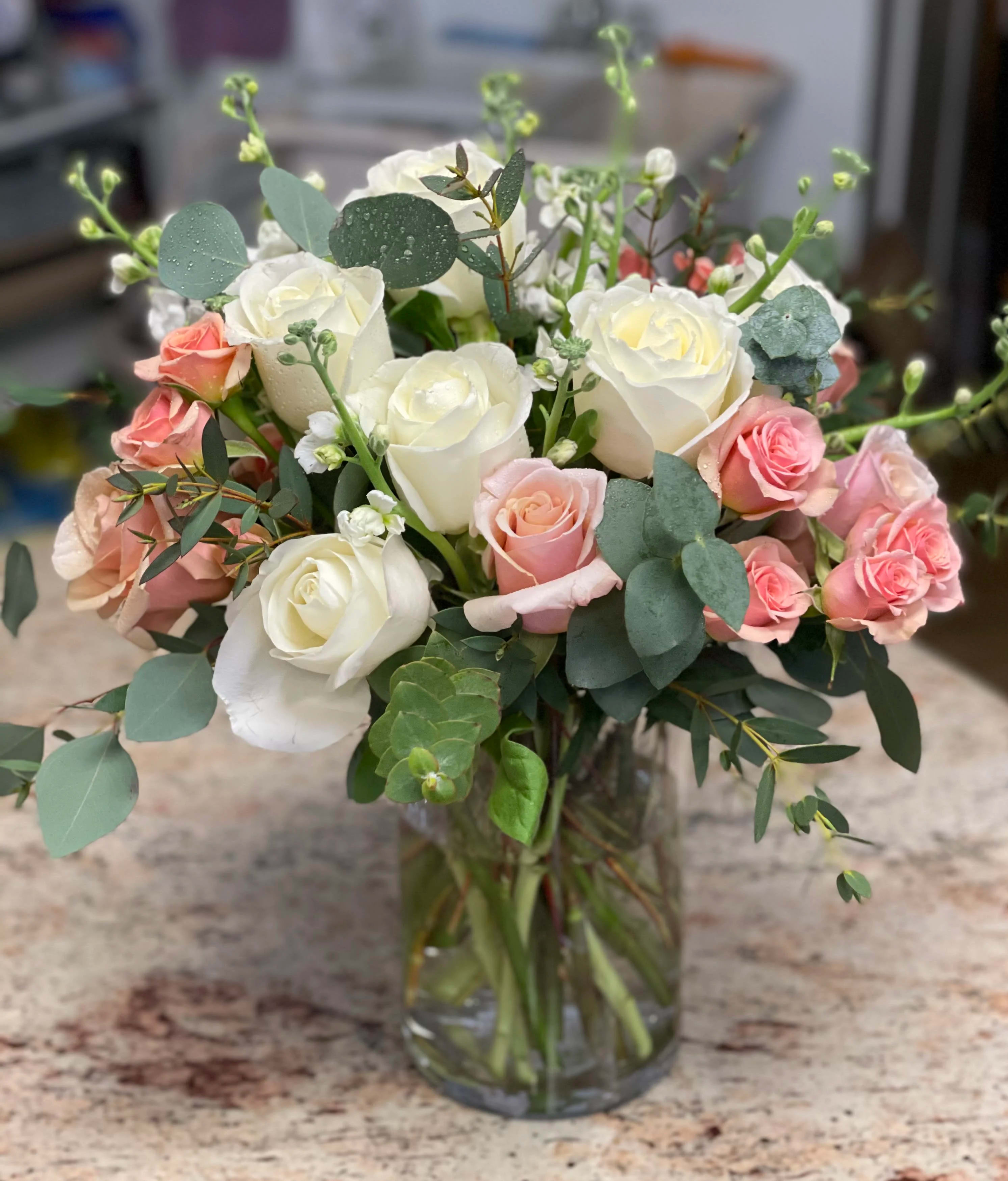 White and pink roses in a clear glass vase