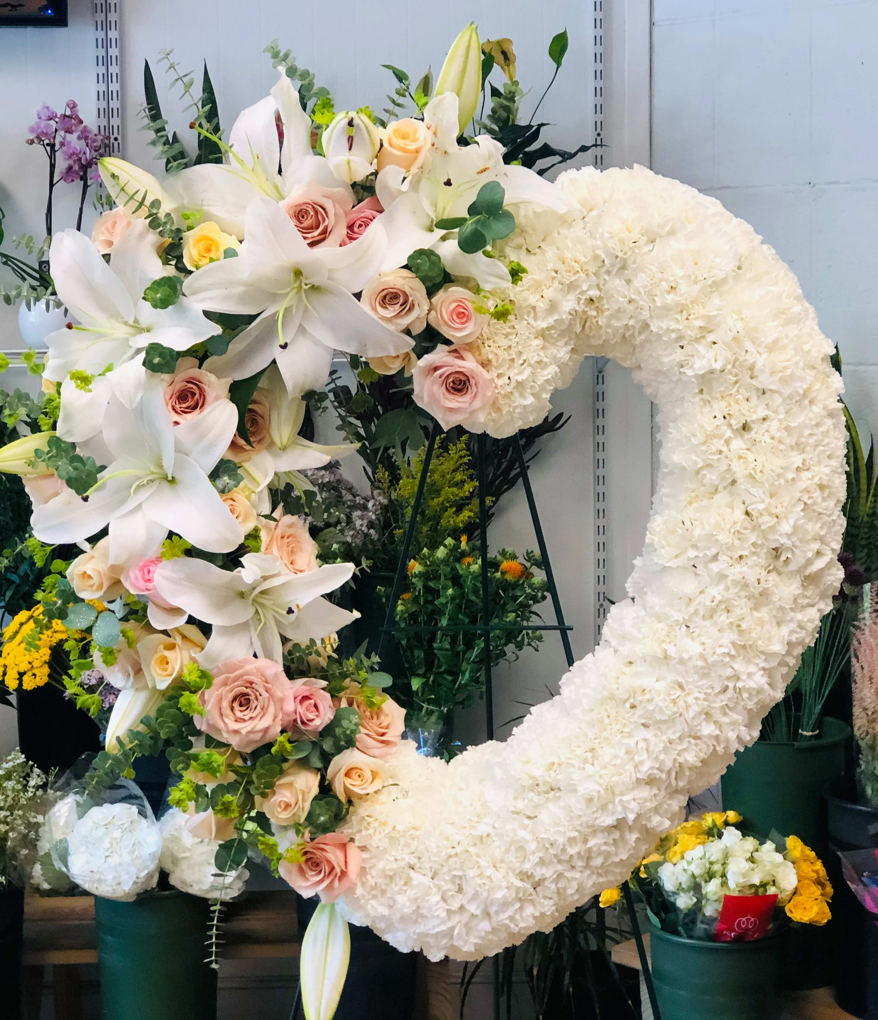 Large floral heart wreath with white lilies, pale roses, and white carnations