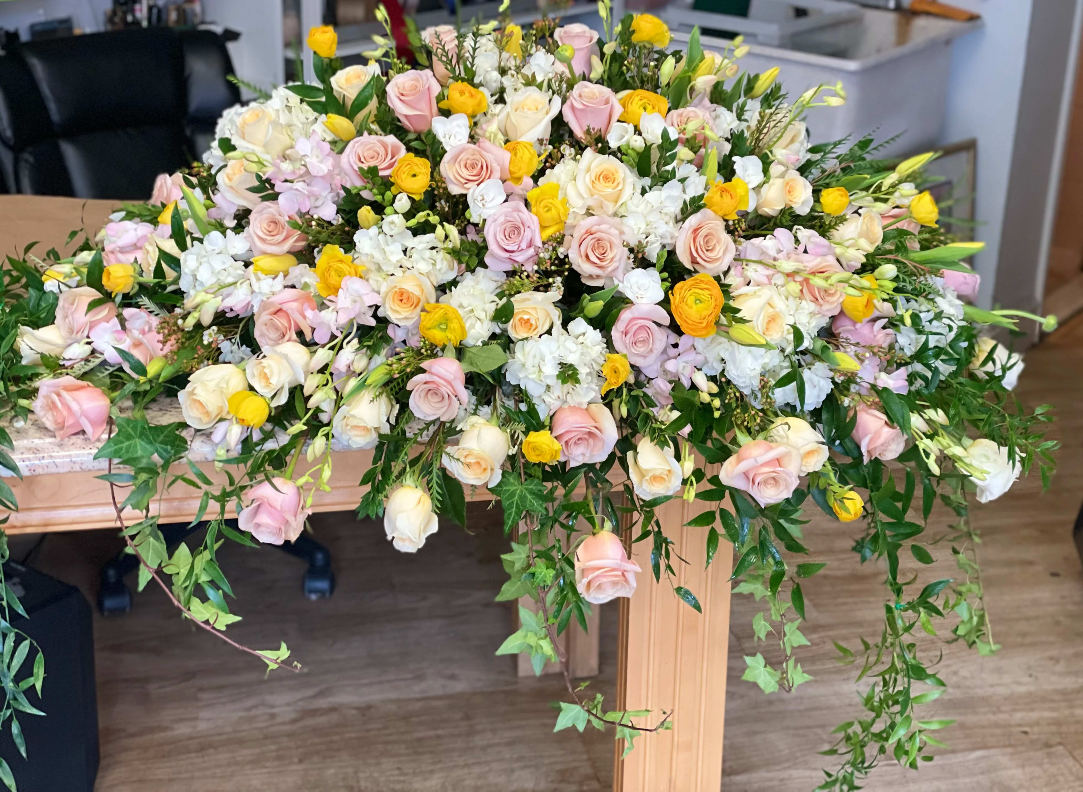 Large pastel floral arrangement with roses, ranunculus, and white blooms
