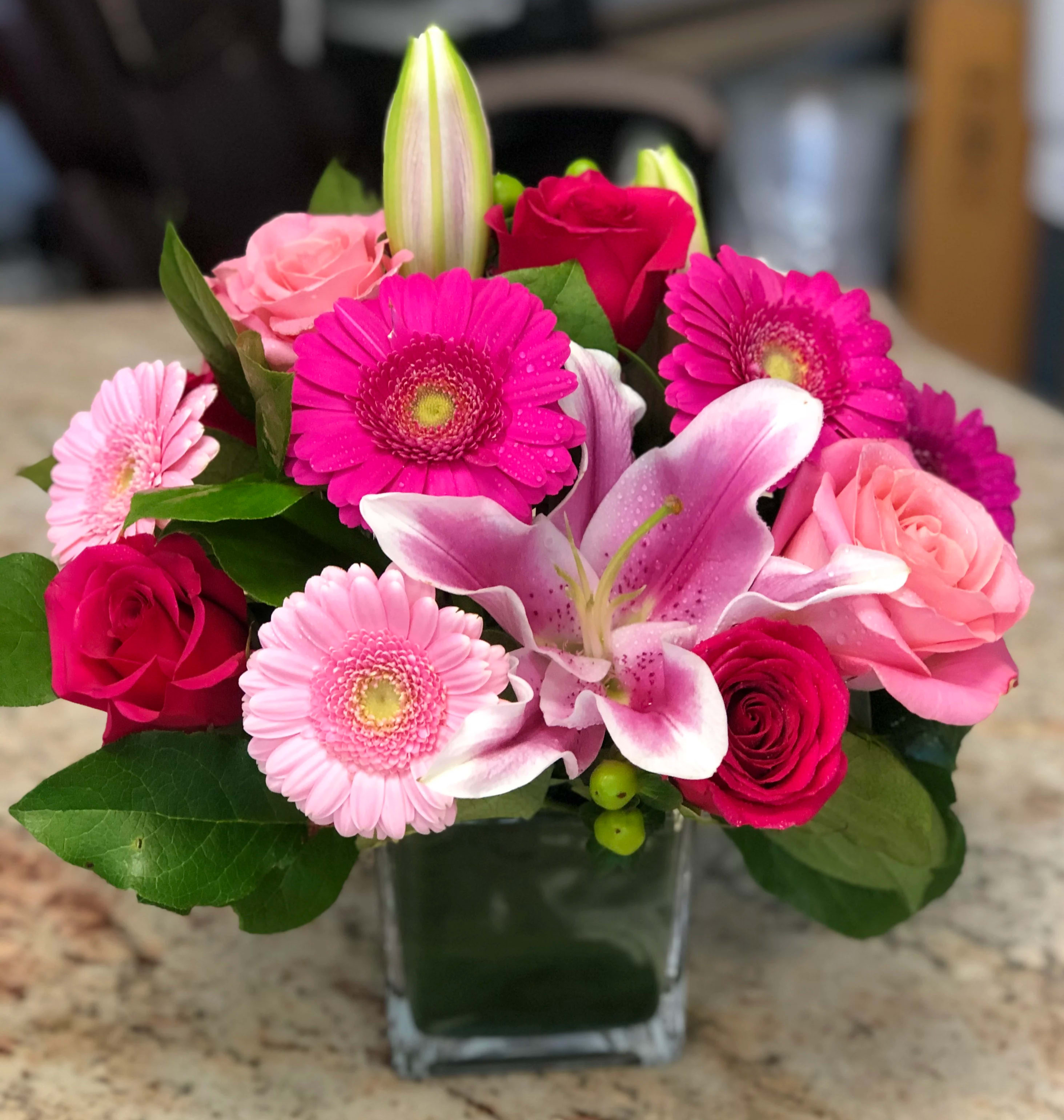 Pink and magenta bouquet with lilies and gerbera daisies in a glass vase