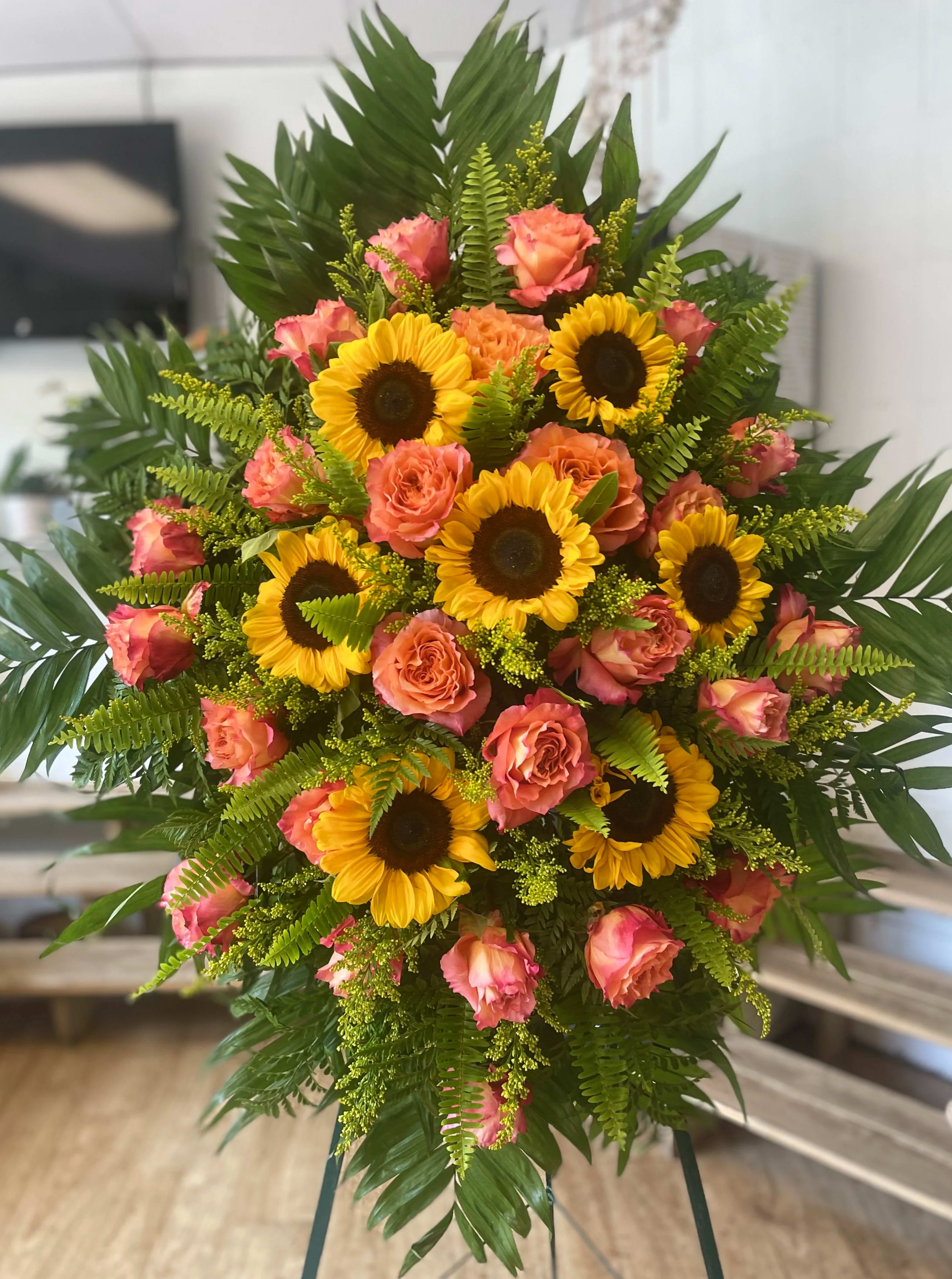 Standing bouquet of sunflowers and pink roses with lush greenery