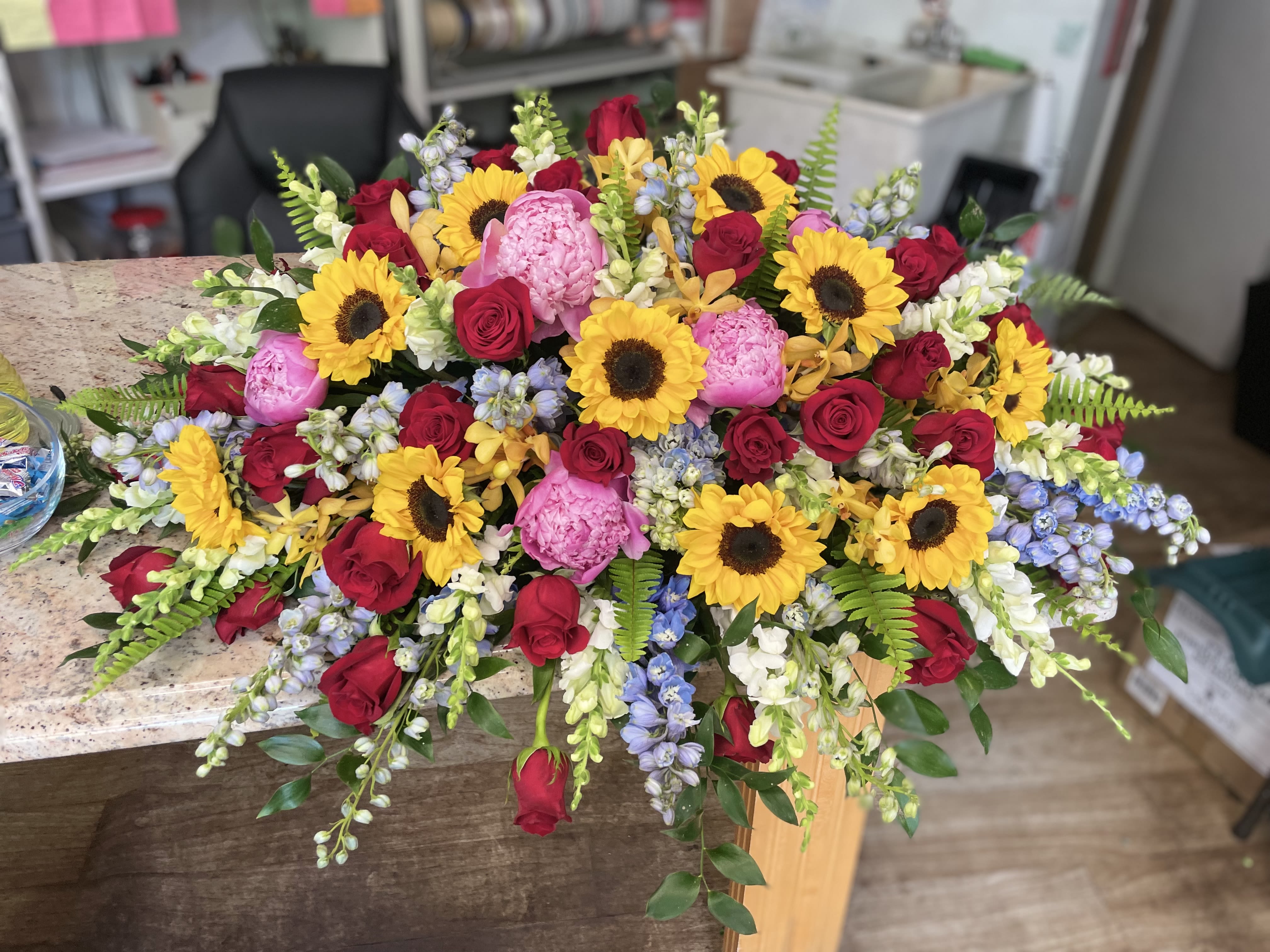 Large mixed bouquet with sunflowers, red roses, and pink blooms