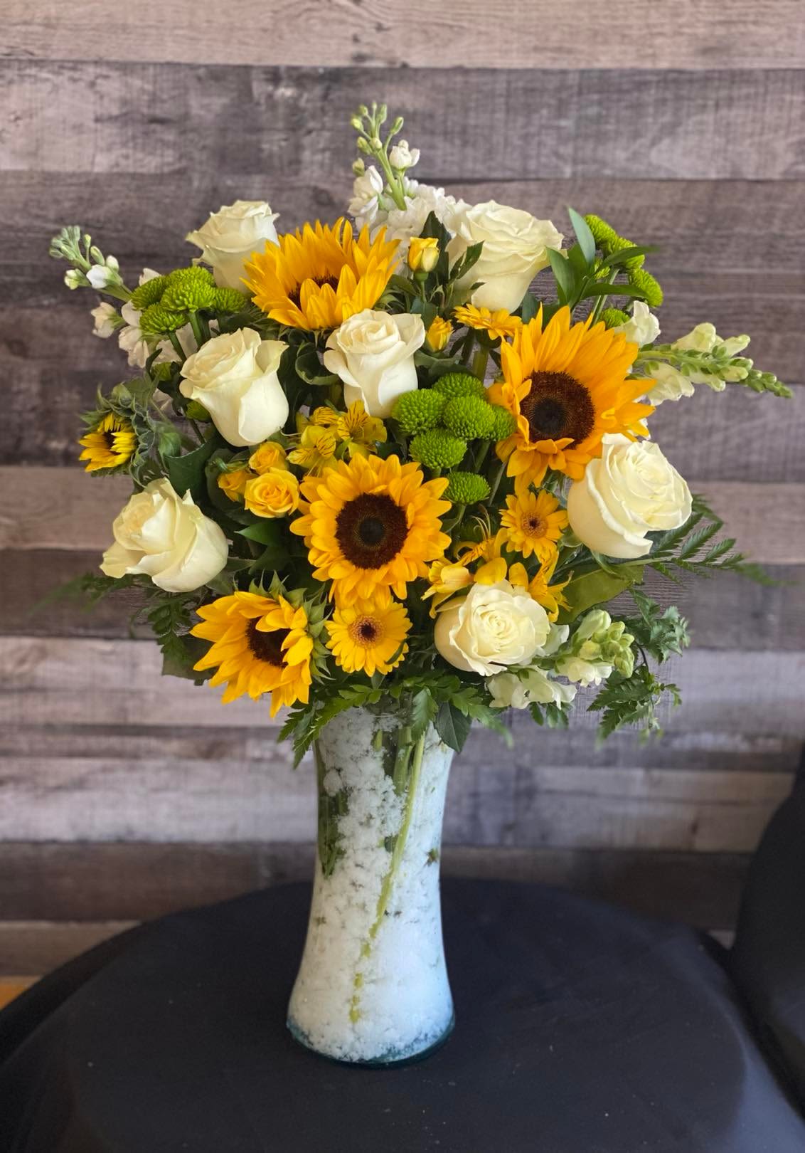 Sunflower and white rose bouquet in a tall vase