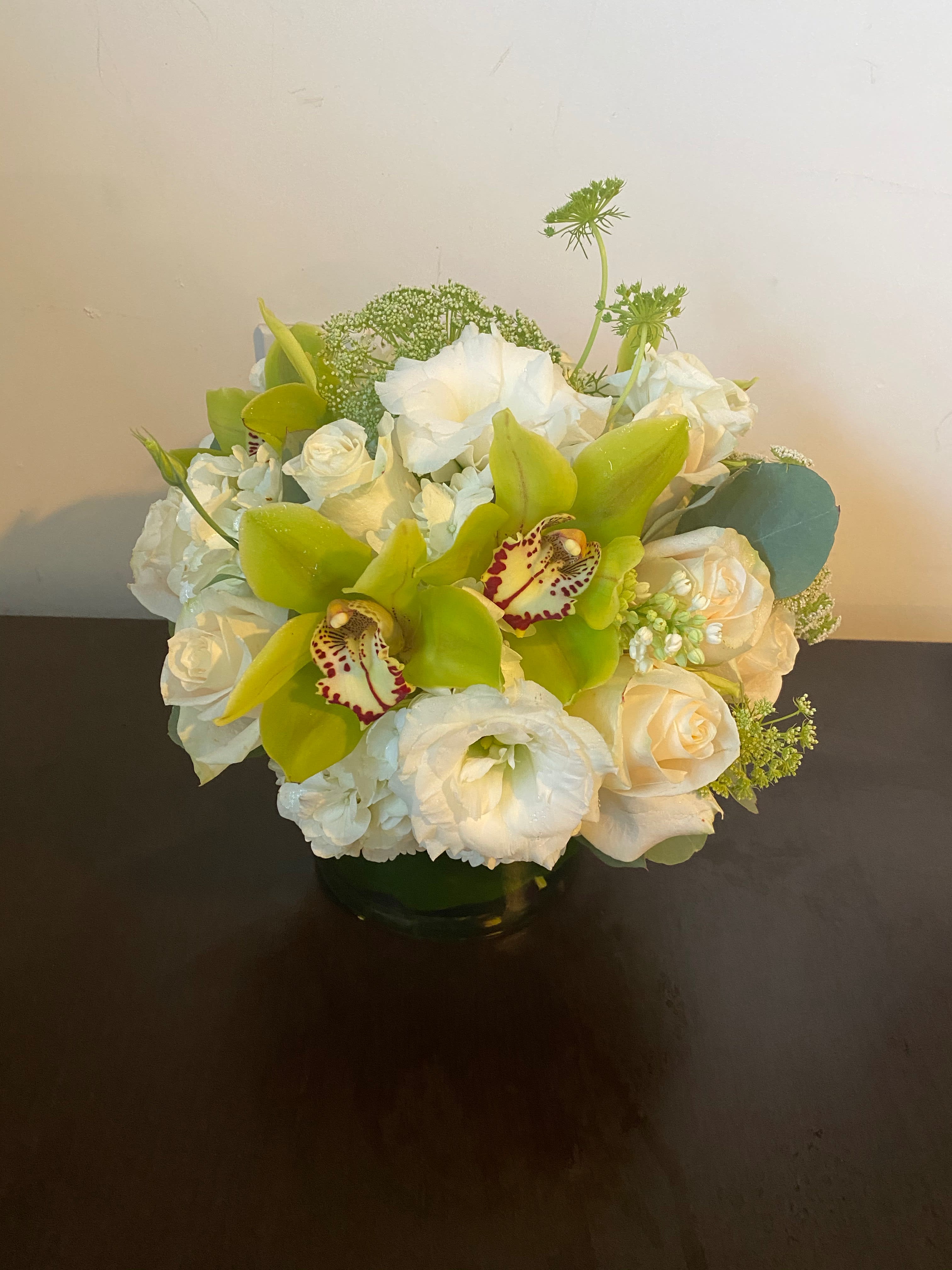 White and green floral arrangement in a glass vase