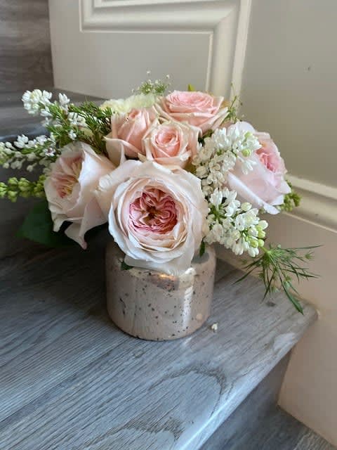 Pink roses arranged in a small ceramic vase