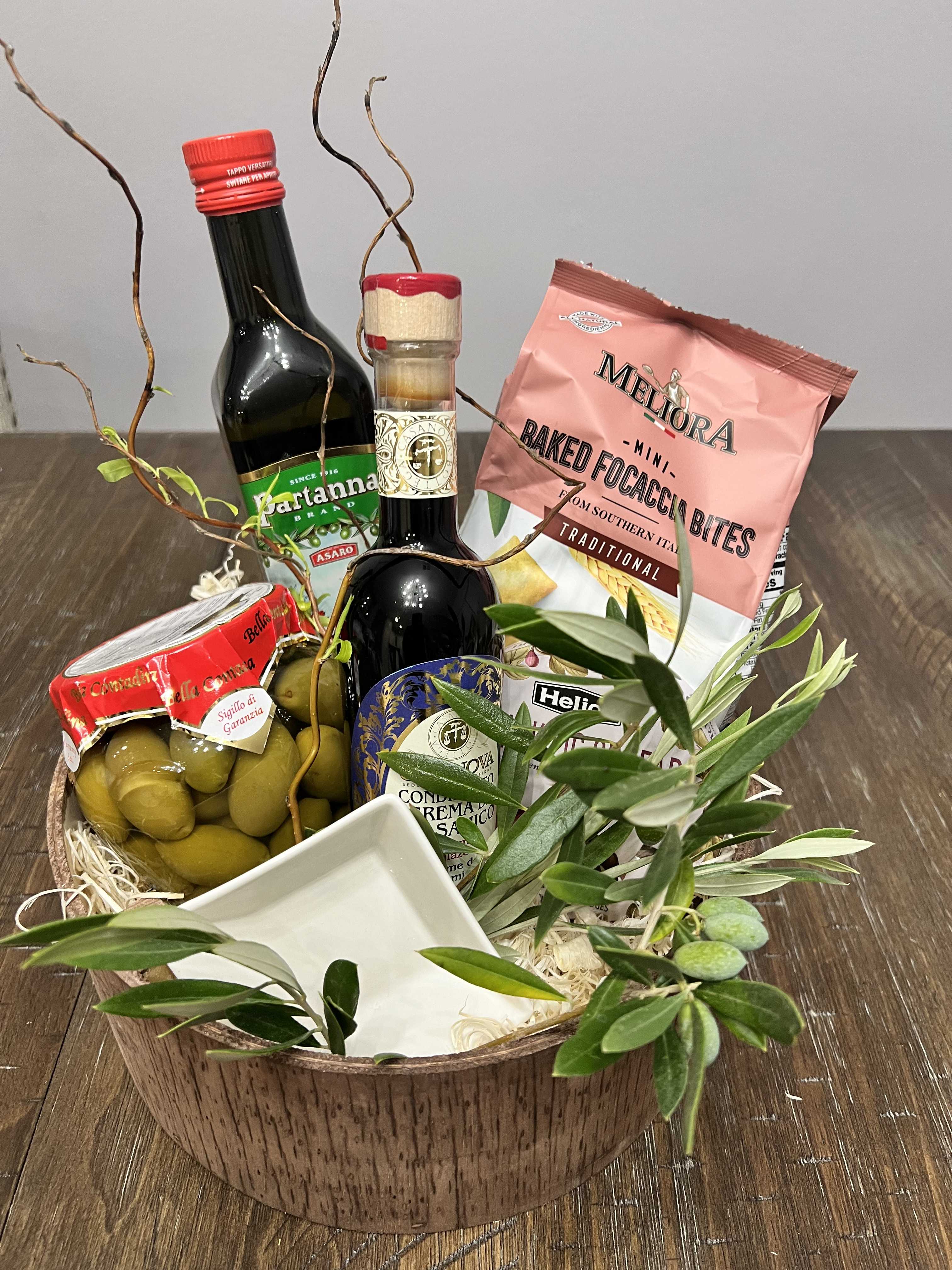 Gift basket with olive oil, olives, crackers, and a small dish