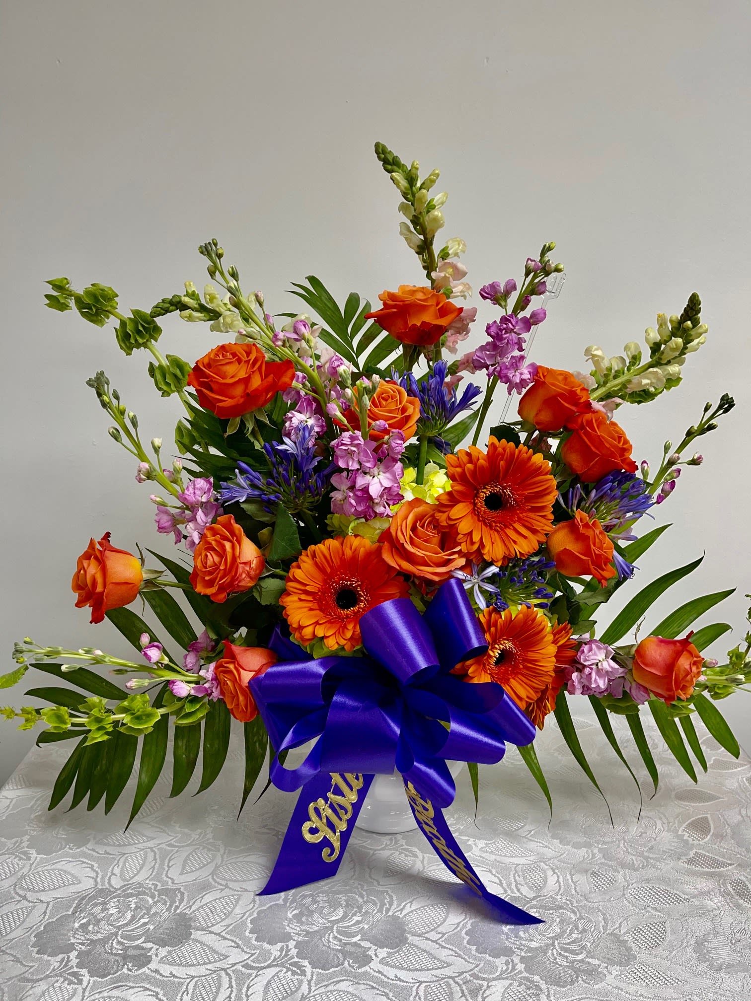 ORANGE SUNSET URN - This colorful and bright funeral urn is representative of a life lived to its fullest. Fitting for any type of service, colors and flowers may change based off of season and availability.