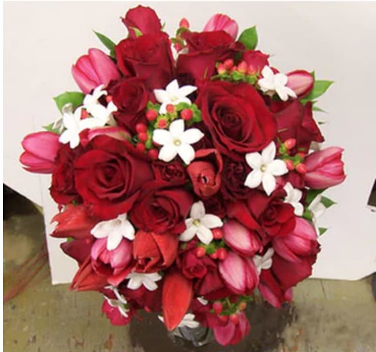 Bouquet of red roses, pink tulips, and white star-shaped flowers